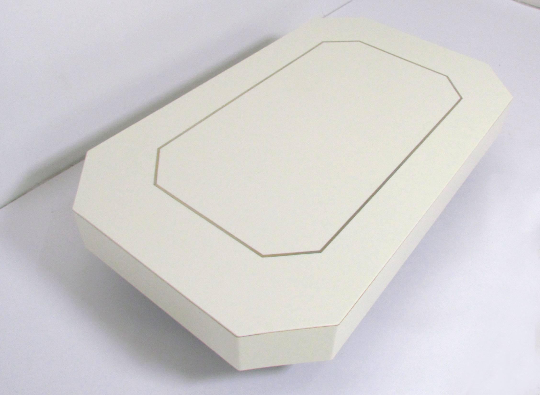 Table basse avec base encastrée qui donne au plateau l'apparence de flotter, forme octogonale en acrylique avec une garniture incrustée de laiton, vers les années 1970.