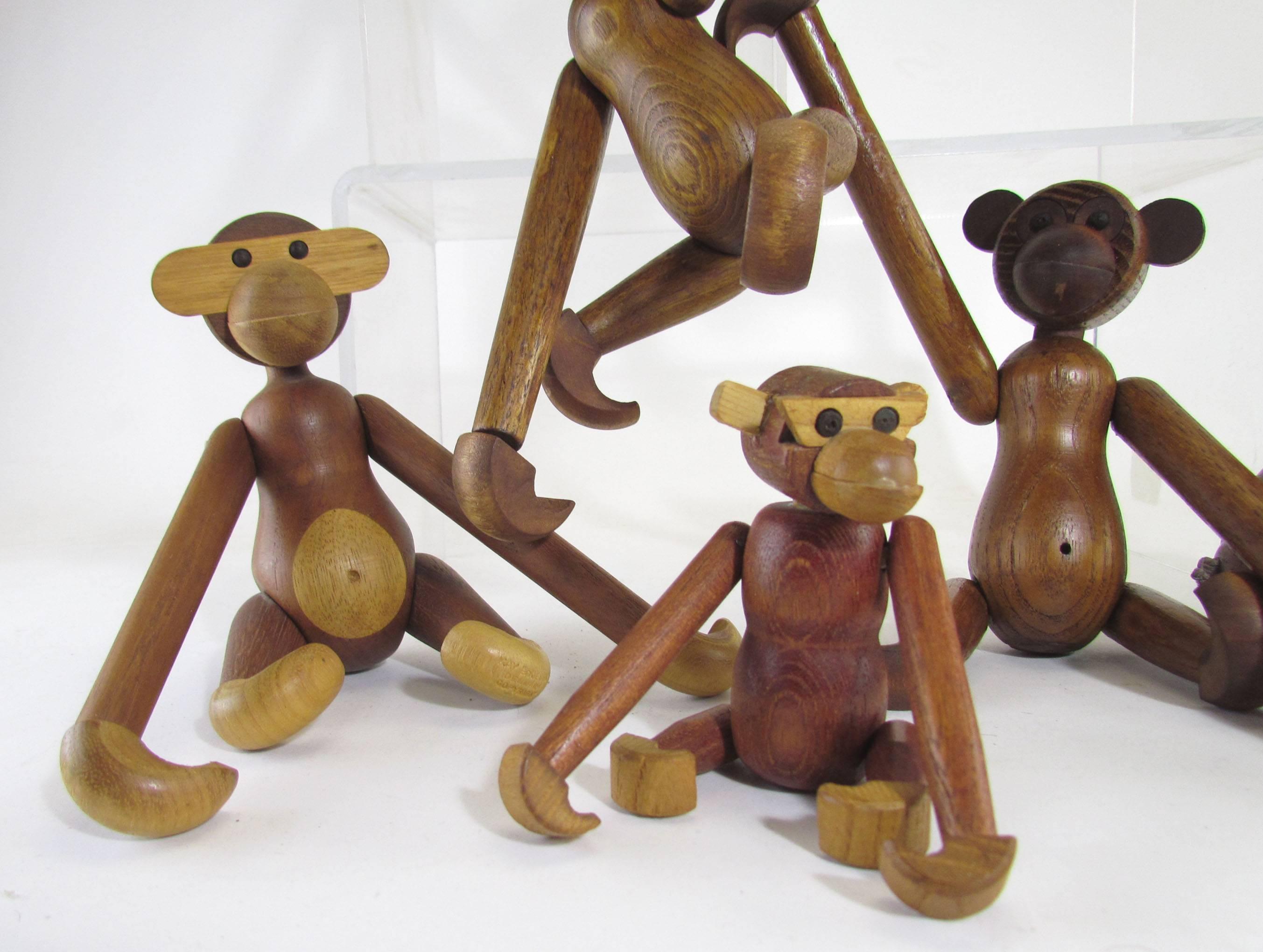 A grouping of seven Mid-Century Modern jointed teak monkey toys, circa 1960s. Two are by Kay Bojesen, Denmark. The others are period Japanese adaptations clearly inspired by that iconic Danish design. The smallest one is 4 1/2