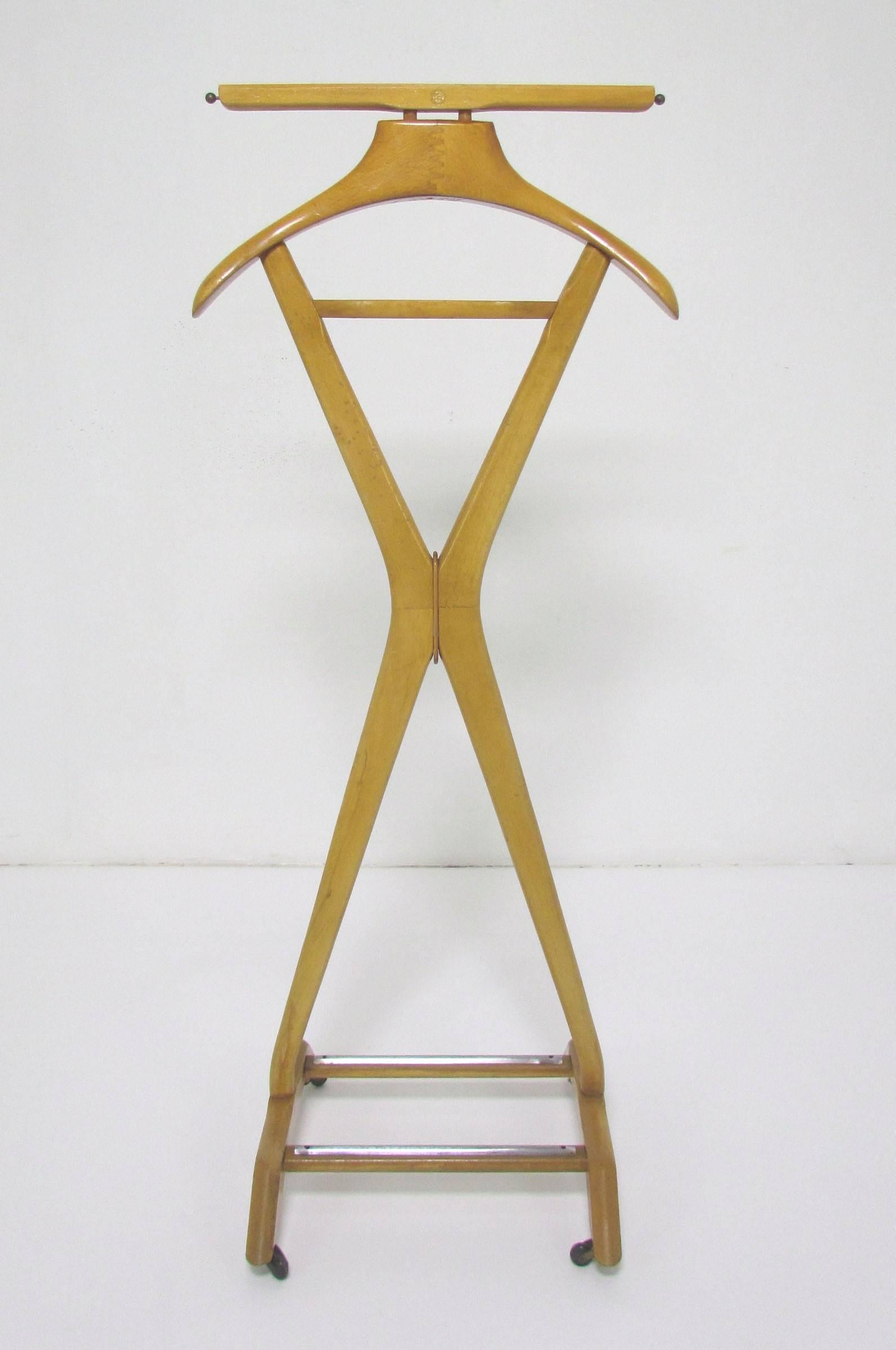 Classic gentleman's valet stand designed by Fratelli Reguitti, Italy, circa 1960s. In the style of Ico Parisi. Includes coat hanger, top rail to drape pants, telescoping rods for ties, and a tray for pocket accessories. Shoes can be placed on the