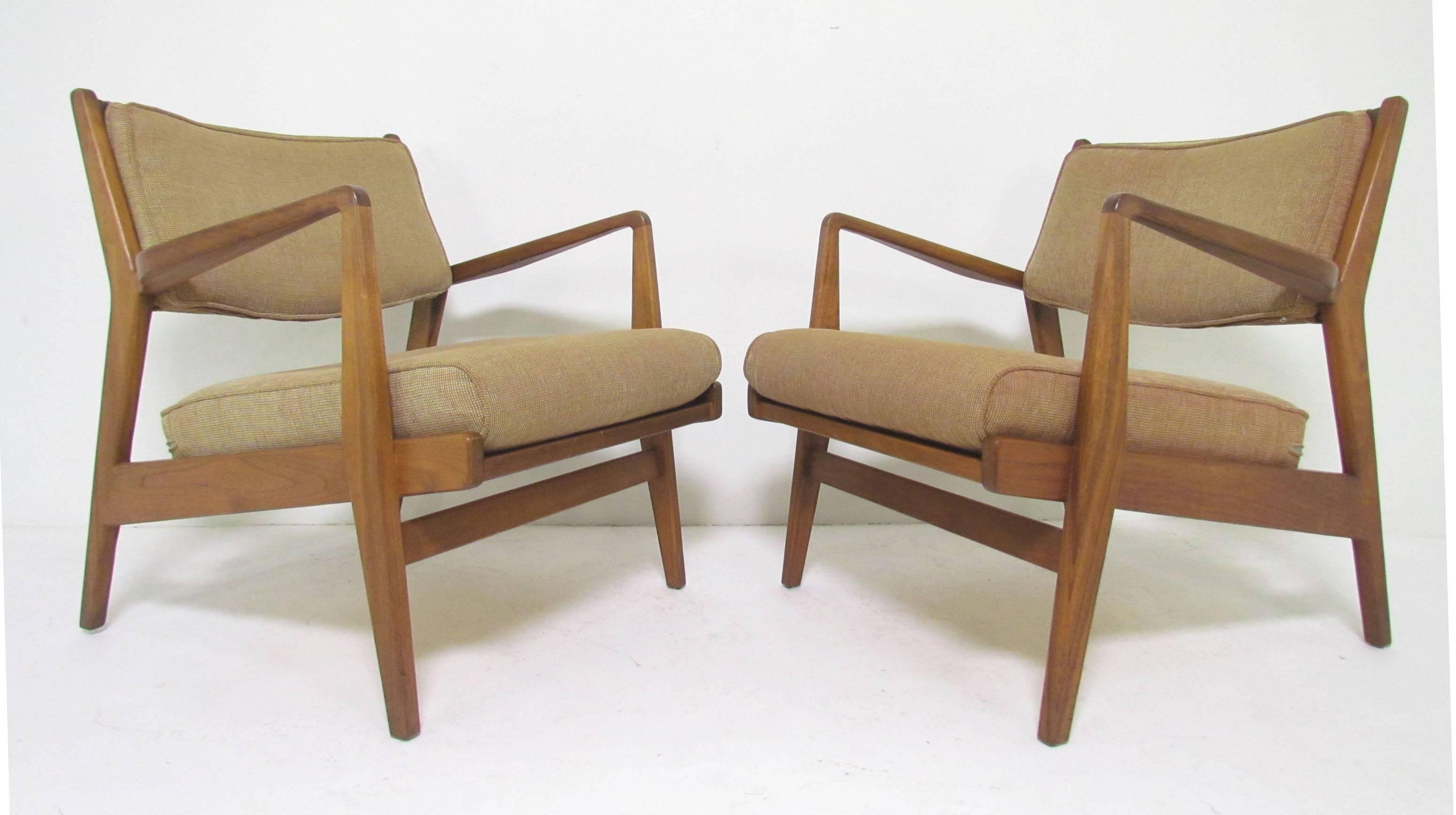 Classic pair of Mid-Century lounge chairs in walnut and original upholstery by Jens Risom. This model was originally designed in 1949 for the Caribe-Hilton Hotel in San Juan Puerto Rico in 1949. Both chairs signed with Jens Risom Design labels and
