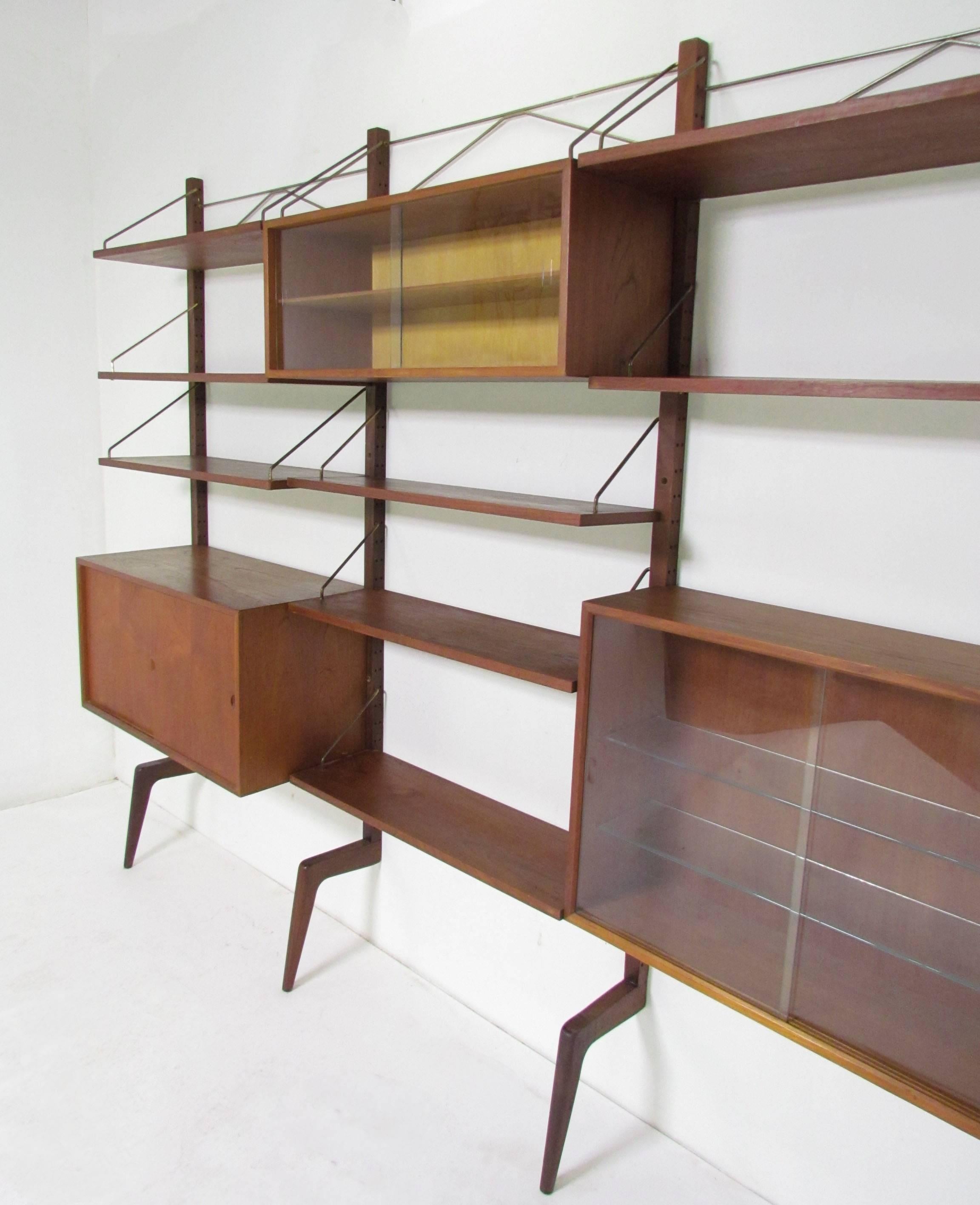 Danish teak three-bay wall unit by Poul Cadovius, circa 1960s featuring a cabinet with sliding teak doors, a large cabinet with glass doors (and two glass interior shelves), a smaller cabinet with glass doors (and one interior shelf) and seven