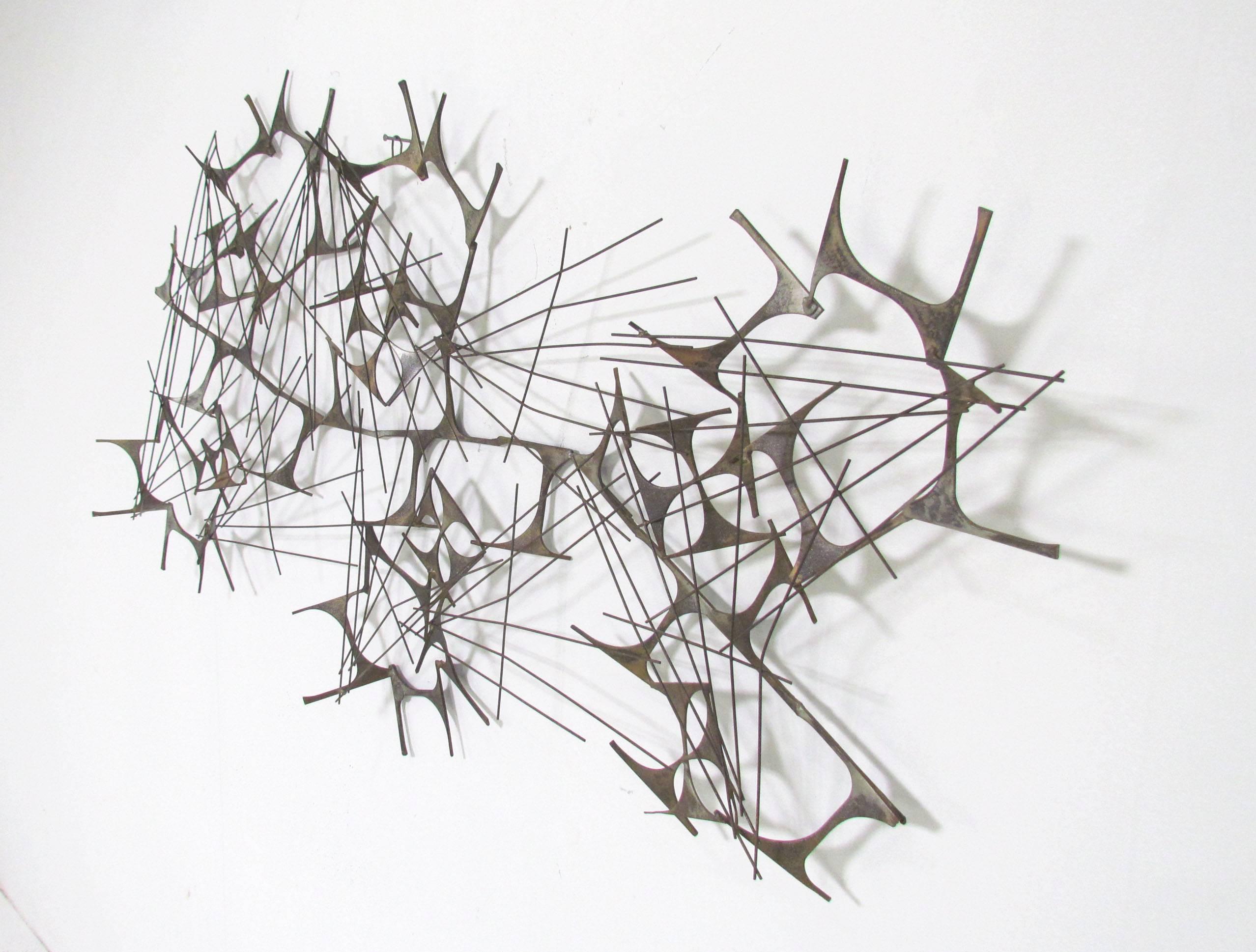 Abstract Brutalist wall-mounted sculpture of brazed sheet steel and nails, circa late 1960s or early 1970s by Marc Weinstein, retaining original medallion for his company 