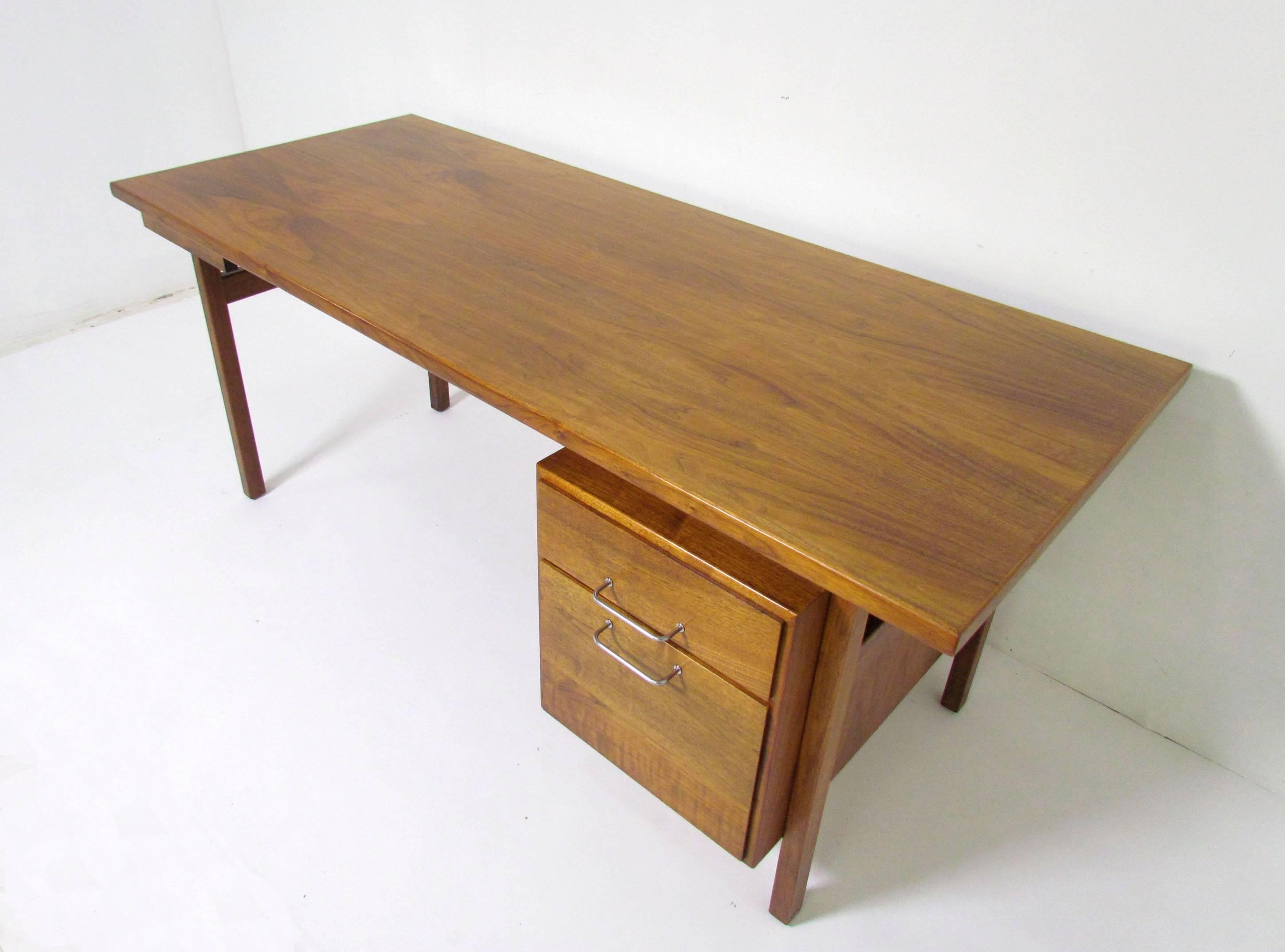 Mid-Century Modern work station desk in walnut by Jens Risom, circa 1960s, with optional (removable) return that mounts to left of seat. Bank of drawers on right include pencil organizer and a deep drawer for hanging files.

Desk measures 72"