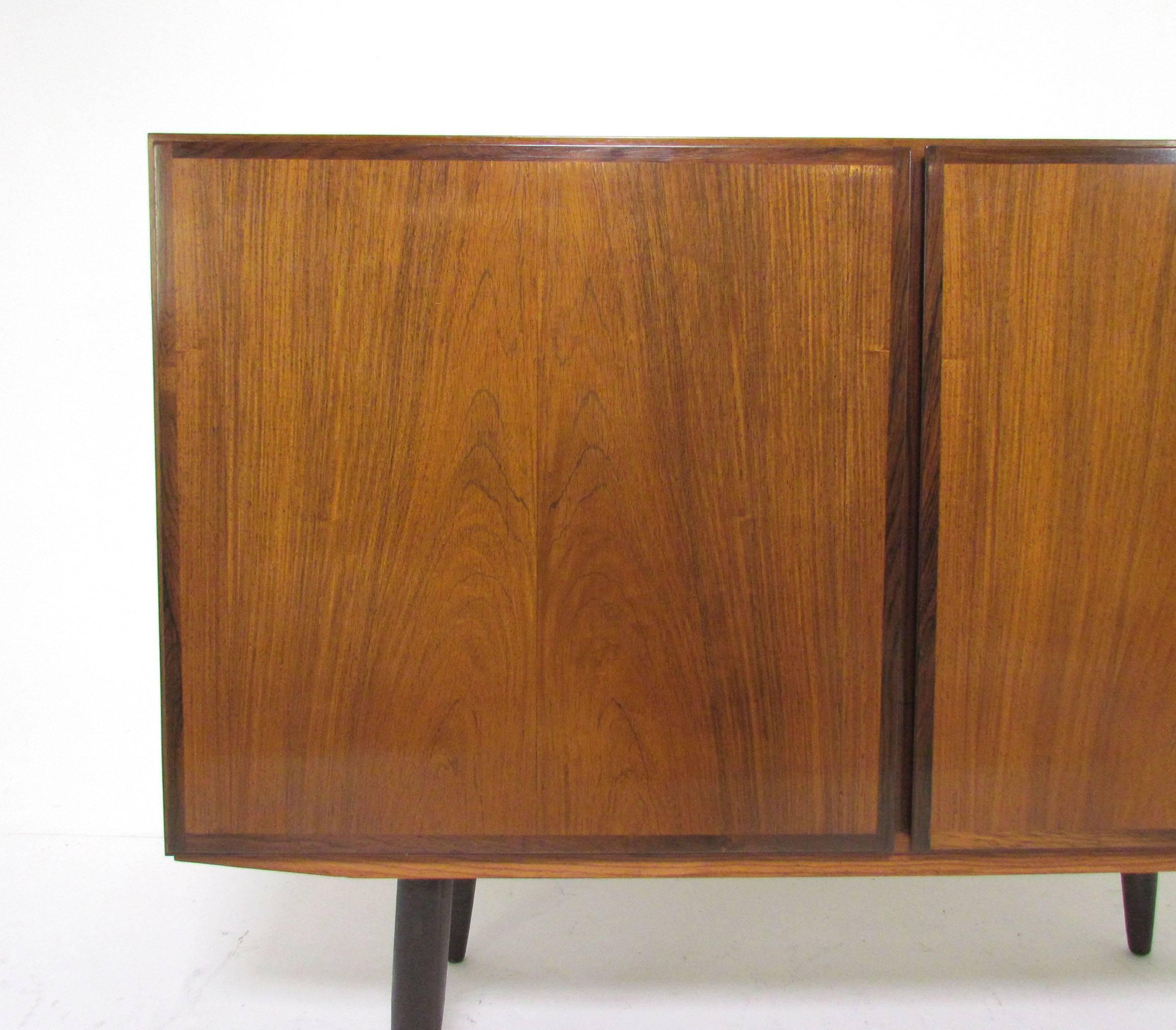 Rosewood two-door sideboard by Gunni Omann for Omann Jun, Denmark, circa 1960s. Features two shallow flatware drawers and adjustable shelves, great size to use as a media cabinet.