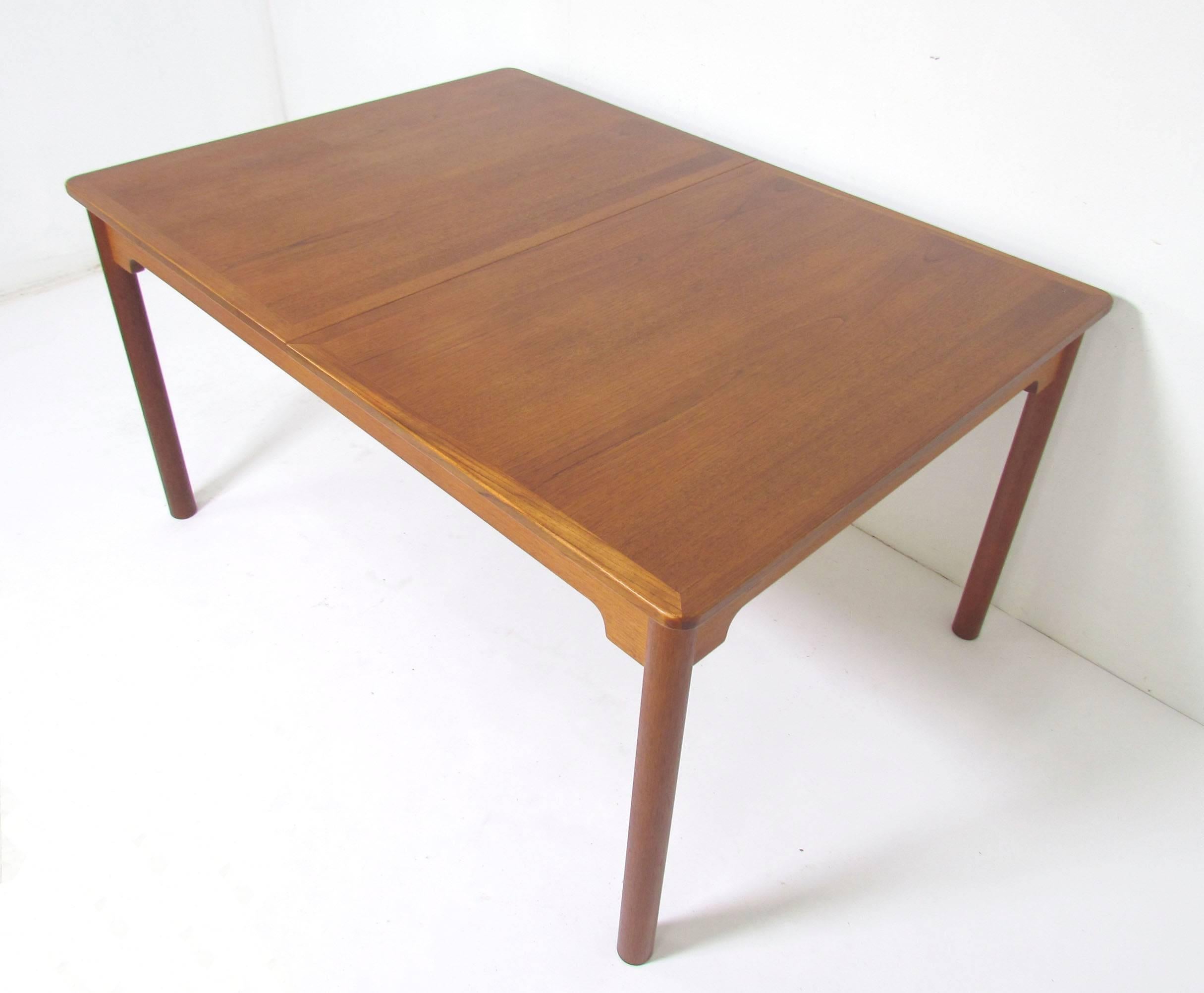Handsome teak dining table on cylinder legs with carved underskirt, designed by Børge Mogensen for AB Karl Andersson & Soner, Sweden, circa 1960s. Includes two leaves that store under the table center.

Measures 55