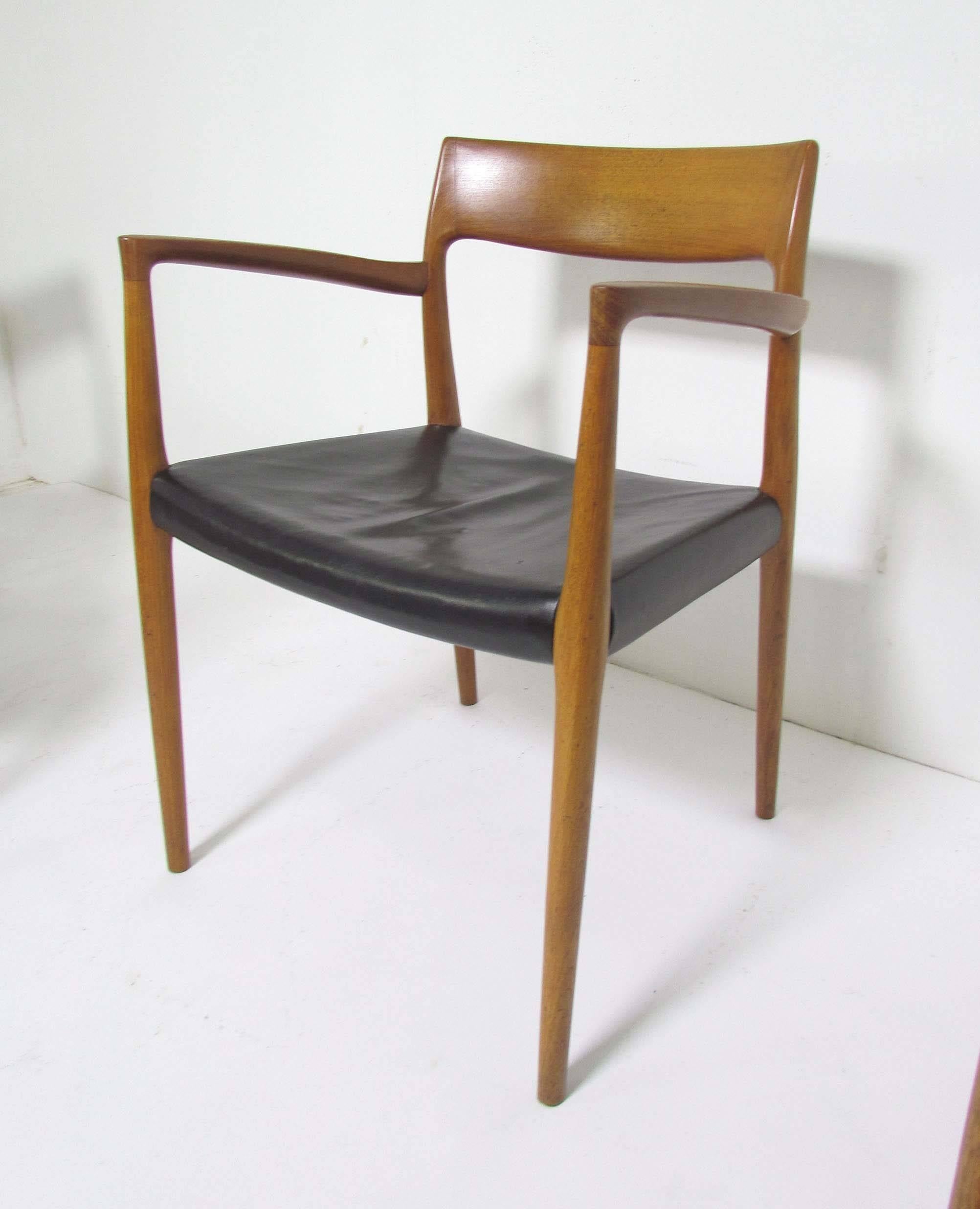 Set of five teak dining chairs (four model 77 side chairs and one model 57 armchair) designed by Niels Moeller for JL Mollers, Denmark, circa early 1960s, in original leather upholstery.

Side chairs measure: 19.5