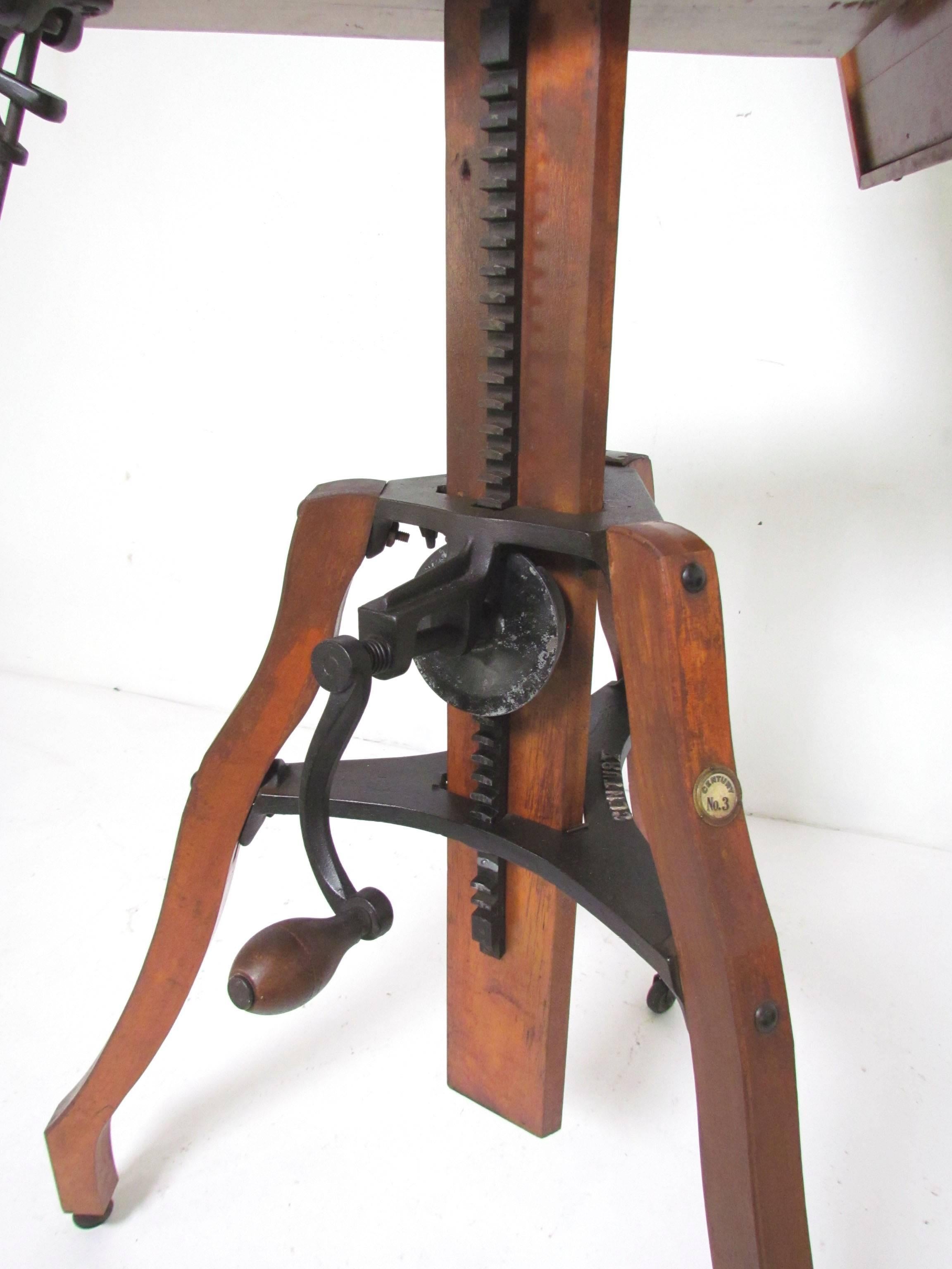 Antique late 19th century pochade or sketching easel on tripod legs with casters, adjustable height via hand crank mechanism, and adjustable tilt via clip and rod mechanism. Can also be used as a standing table to sketch flat. Marked "Century