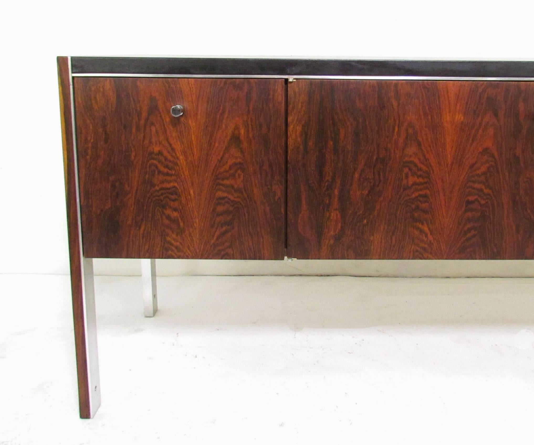 Rosewood credenza with leather top and aluminum accents, by Biltrite dated 1978. Biltrite was authorized to produce Herman Miller designs in Canada.

bookmatched doors and drawer fronts, finished rosewood back. 

Note cabinet includes original