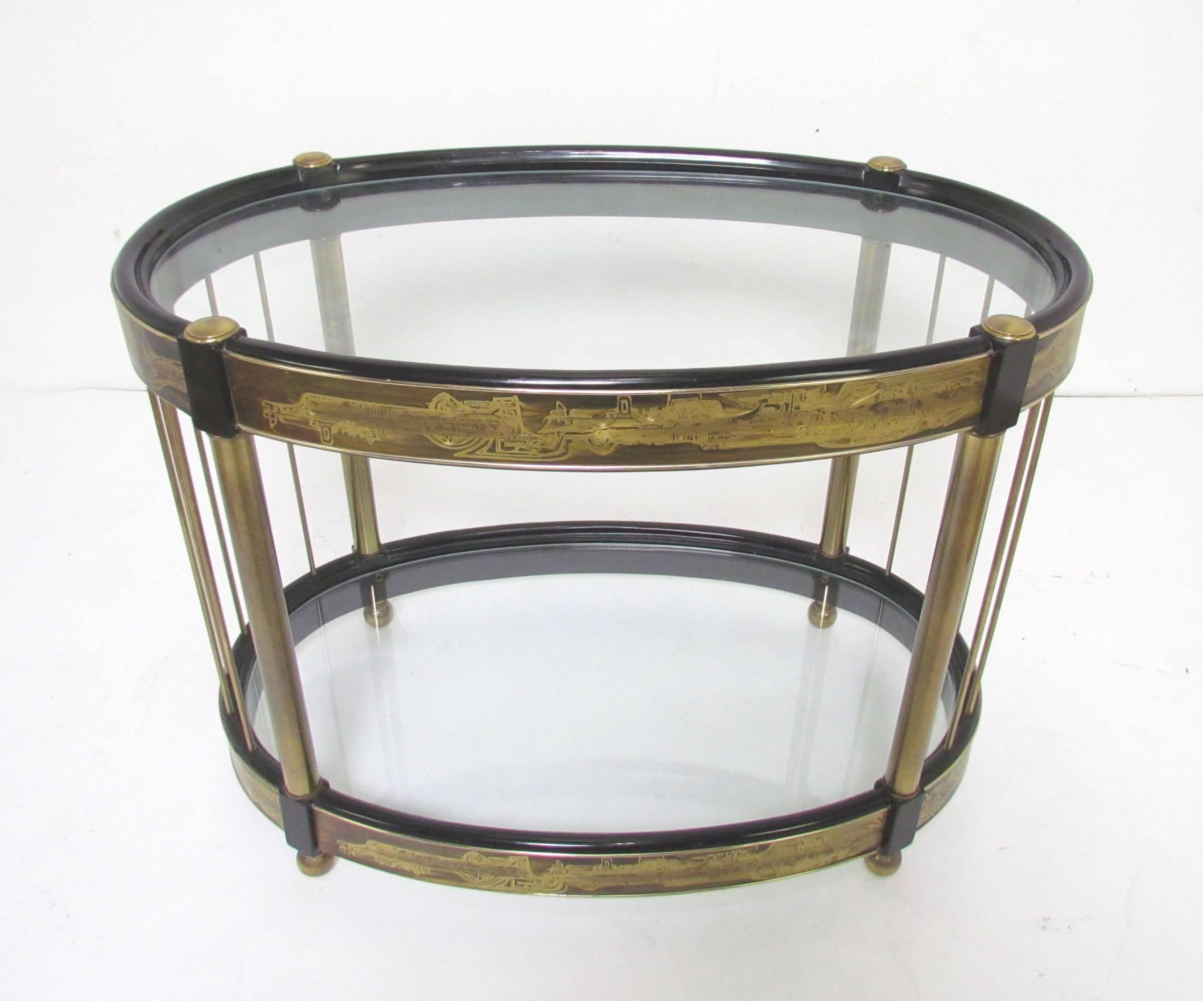 Two-tiered side table designed by Bernhard Rohne for Mastercraft, with abstract acid etched decoration on brass panels, affixed to a lacquered wood frame. Would make an excellent (stationary) bar or drinks table.