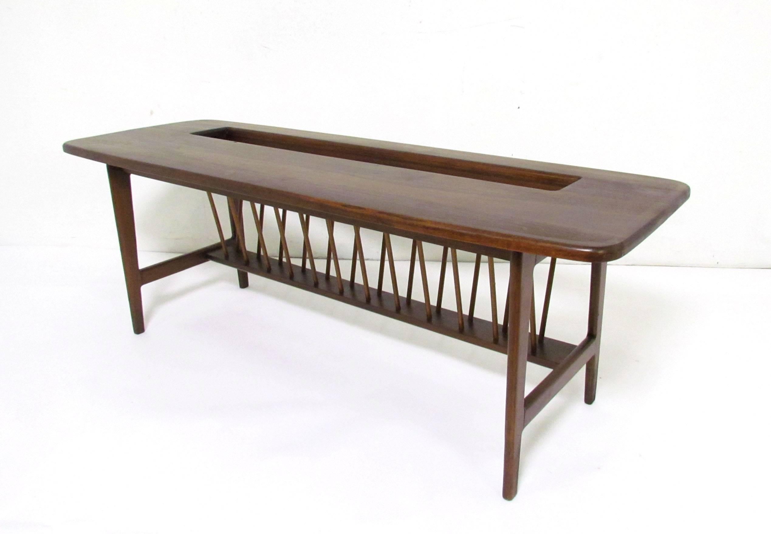 Midcentury coffee table in walnut by Arthur Umanoff with built-in storage rack for magazines. One of his rarest and most compelling designs for Washington Woodcraft.