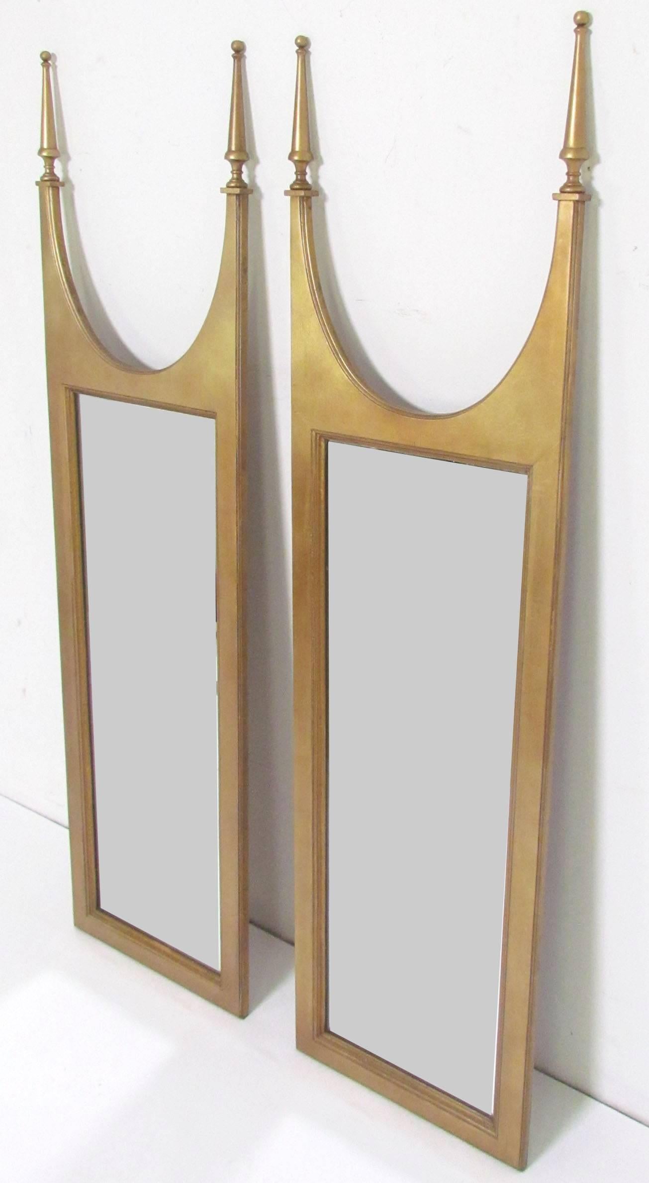Pair of mirrors, in giltwood, with arched tops and spires, in the manner of Tommi Parzinger, circa 1960s.