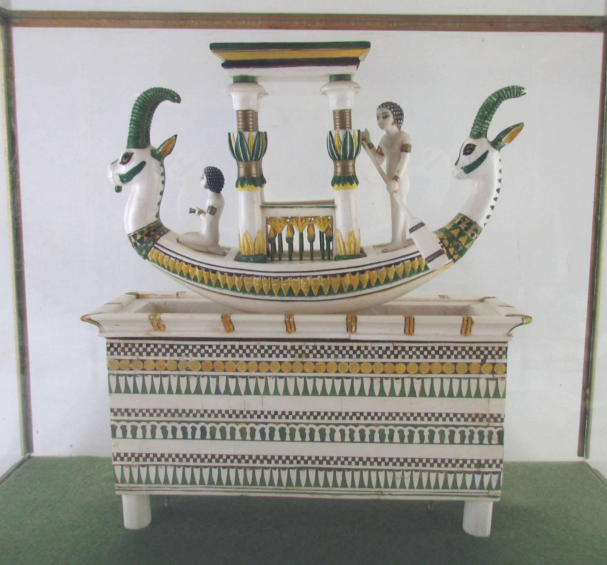 A hand built replica of an Egyptian ceremonial boat unearthed from the tomb of Tutankhamun, considered the earliest known boat model in existence. This meticulously crafted work features individual tile work of hand-painted bone and comes from the