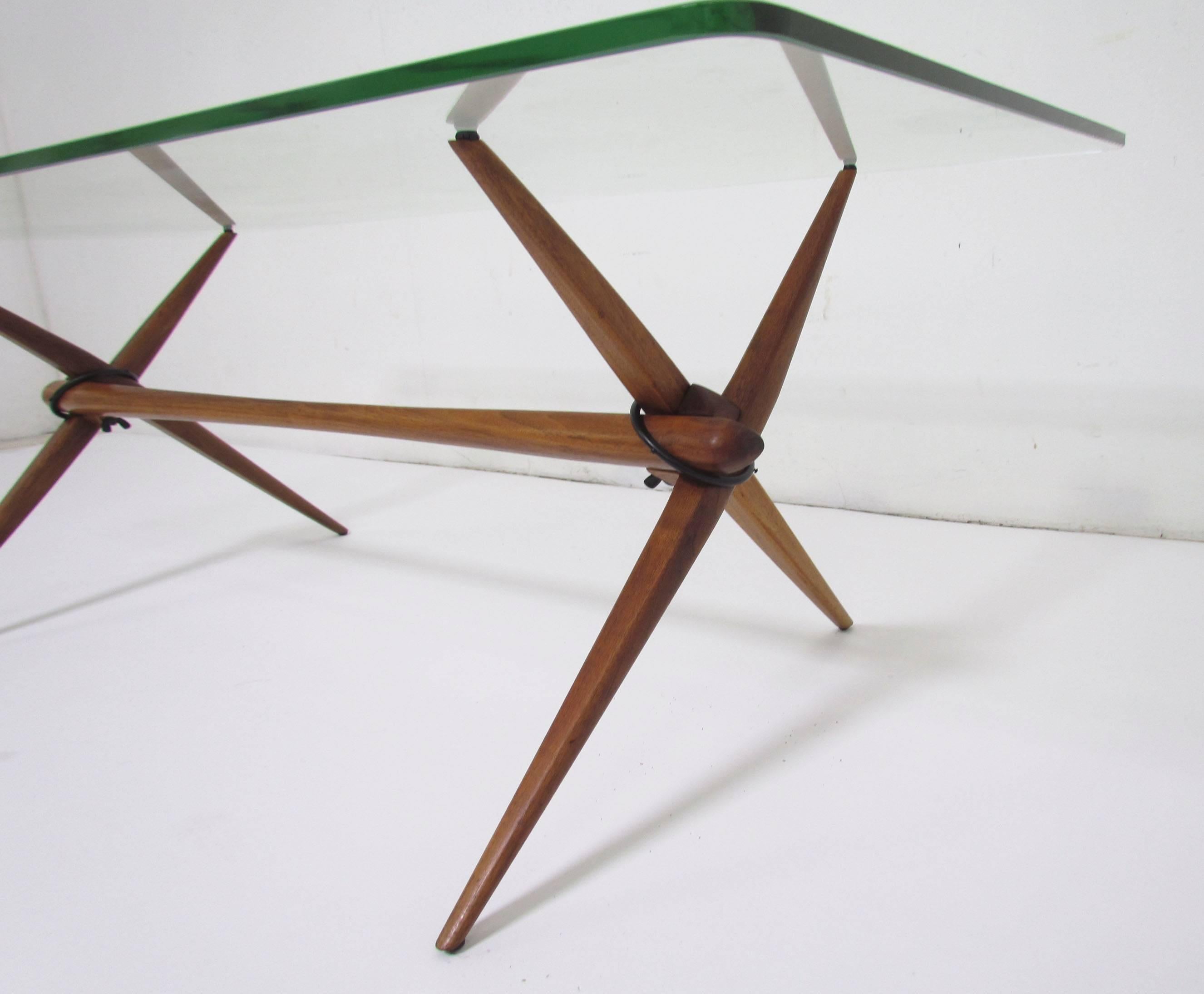 Mid-Century Modern coffee table in teak with sawhorse legs, glass top with rounded corners. Includes optional tray for displaying small objects or plants, circa 1960s. Although Danish modern in design, the table legs feature an ingenious 