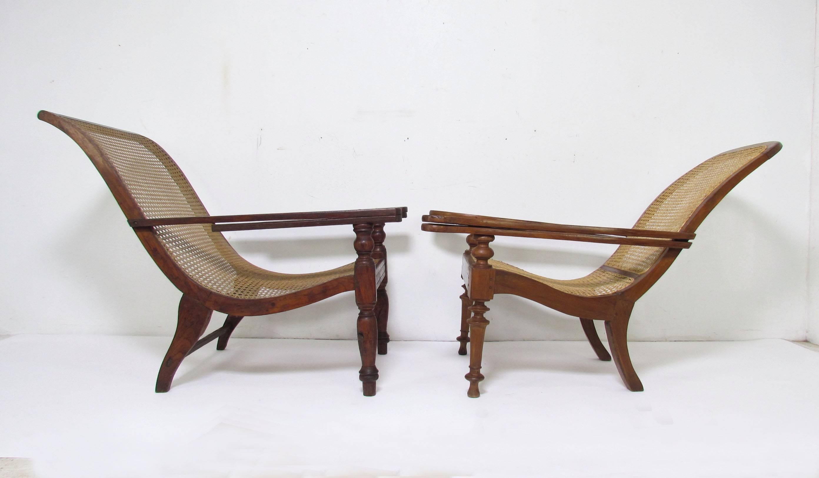 CHAIR ON THE LEFT IS SOLD.
 Antique Anglo-Indian long paddle arm plantation lounge chairs, circa late 19th century.

Both retain their "swing out" extensions for reclining with legs up.

SOLD: The one of the left measures 26.25" wide,
