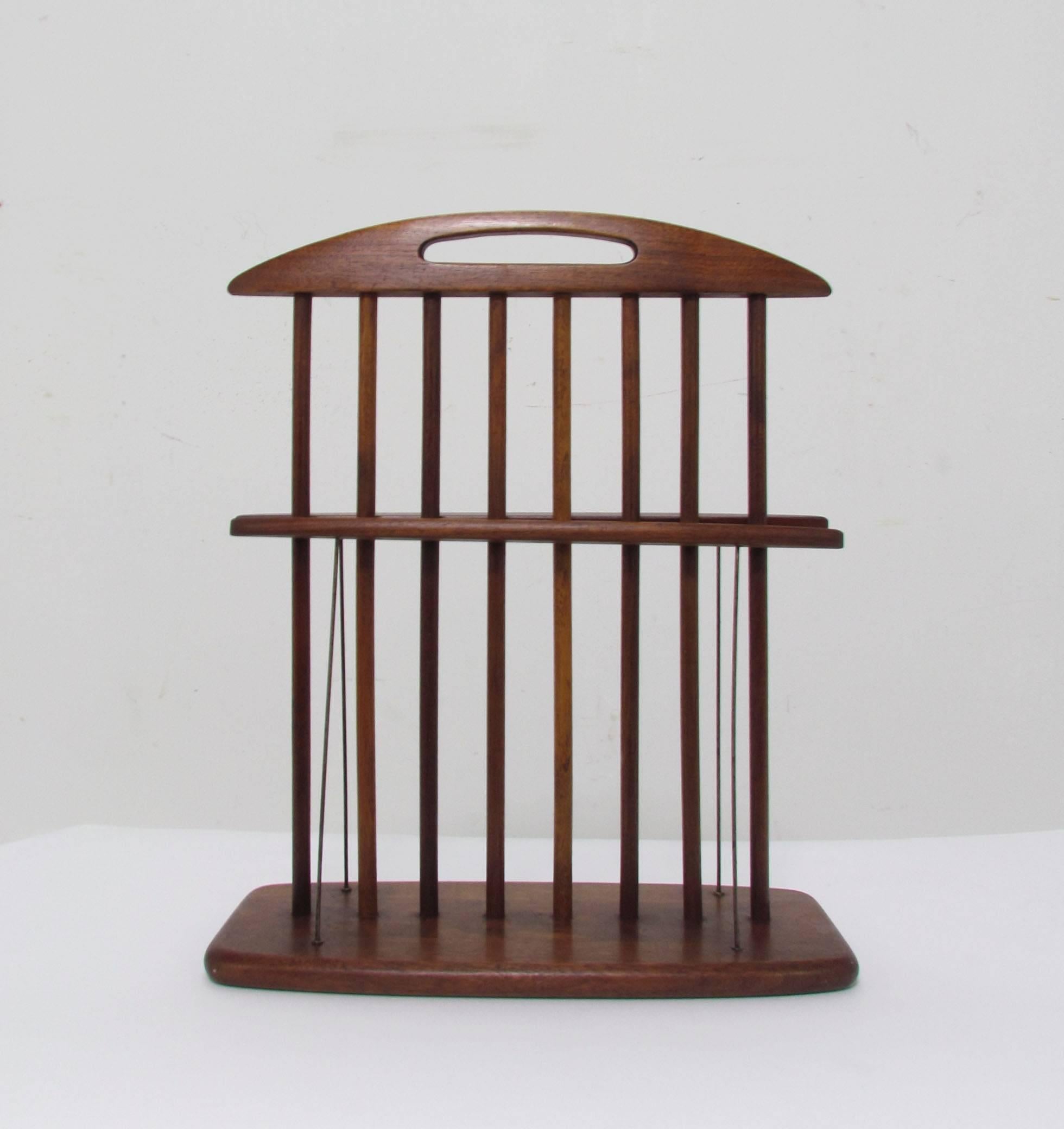 A finely crafted Mid-Century Modern magazine rack in walnut with metal 