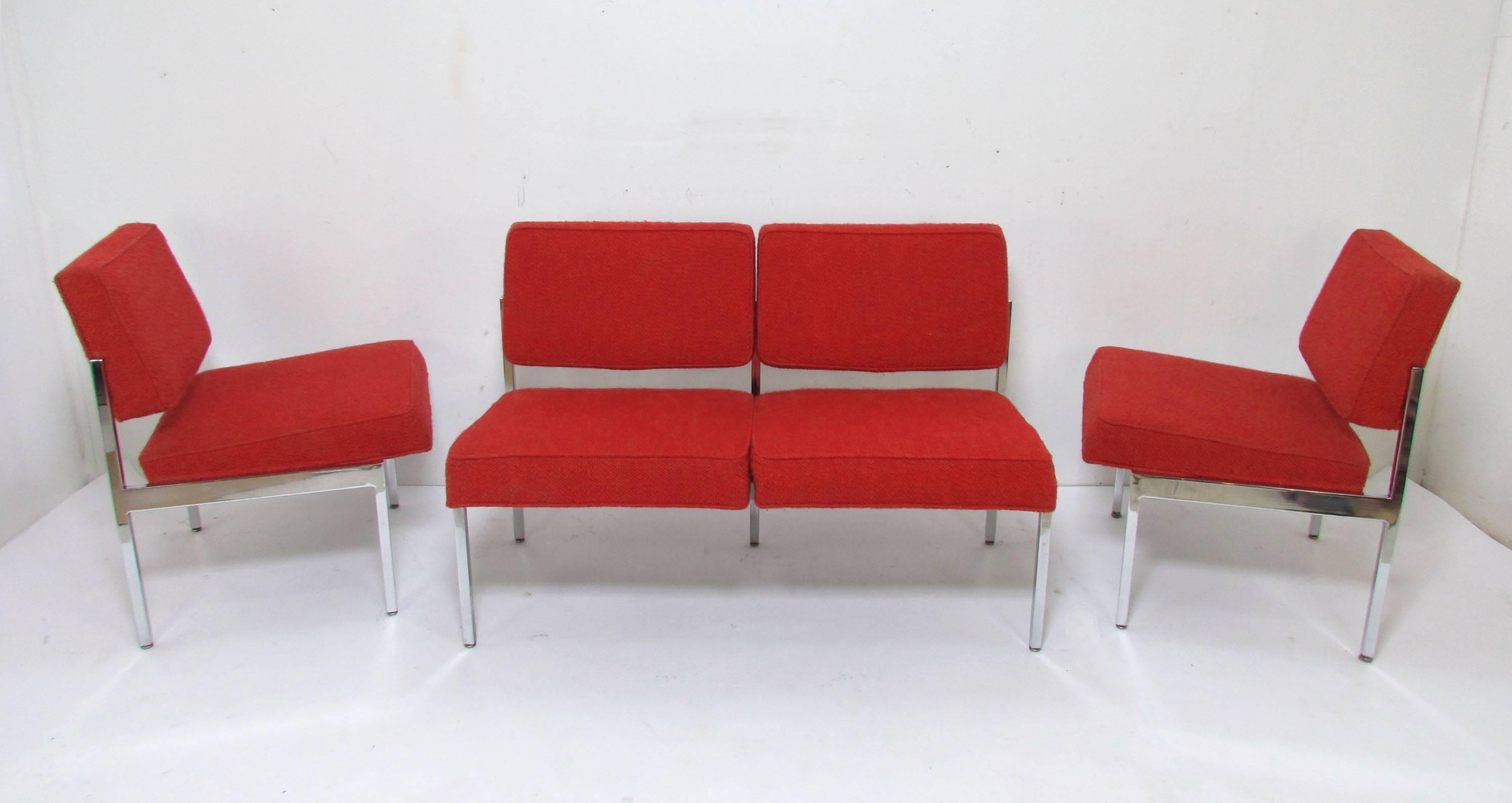 A pair of lounge chairs with matching two-seat sofa by Steelcase, circa 1960s, clearly influenced by the designs of Florence Knoll. Bright chromed steel frames and original nubby red upholstery.

Loveseat sofa measures 46.75