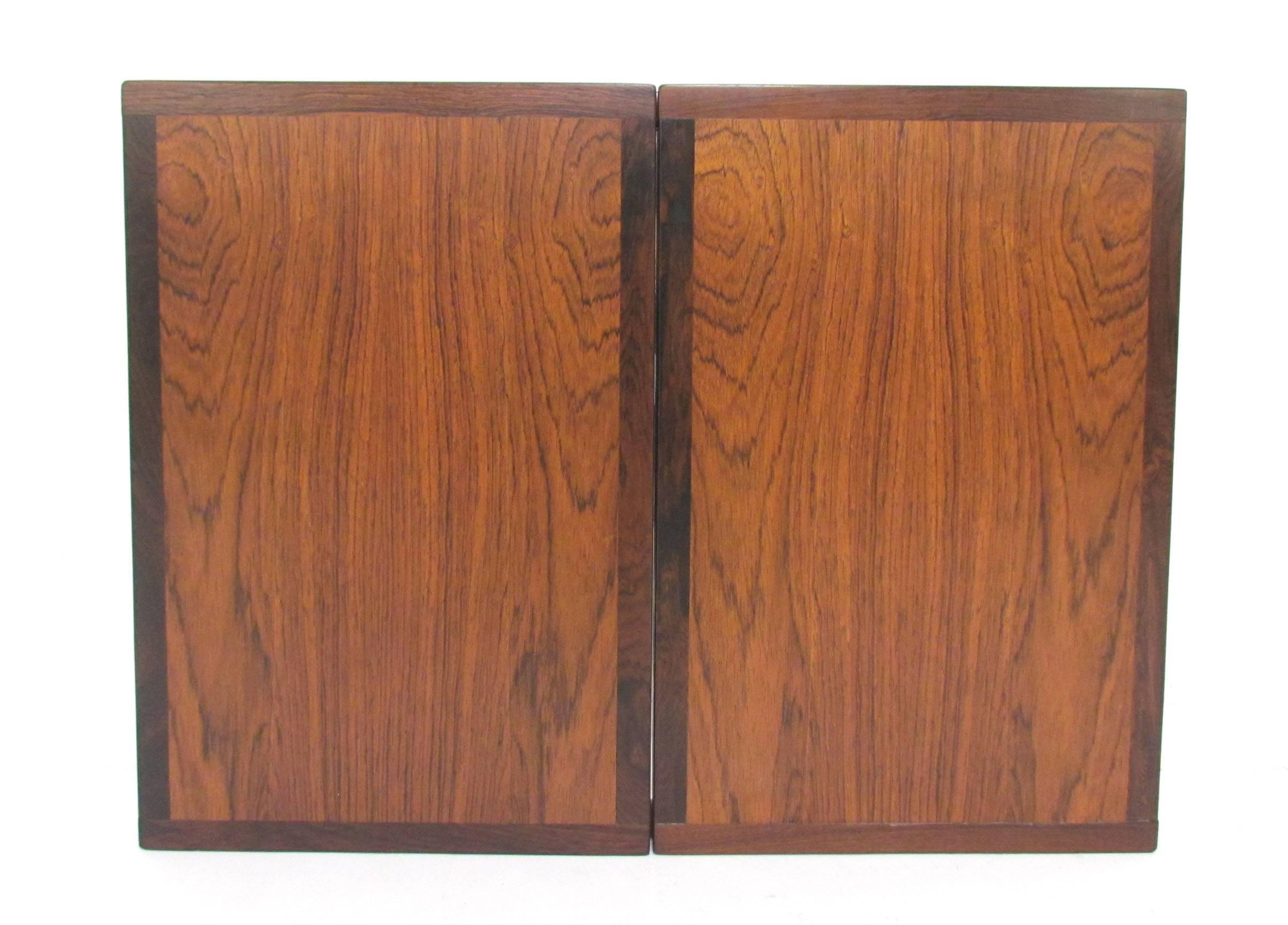 Wall mounting mirror with hinged side panels in Brazilian rosewood, designed by Kai Kristiansen for Aksel Kjersgaard, Denmark, ca. 1960s.   When closed, the beauty of the rosewood is even more evident.

When closed, this measures 22.75
