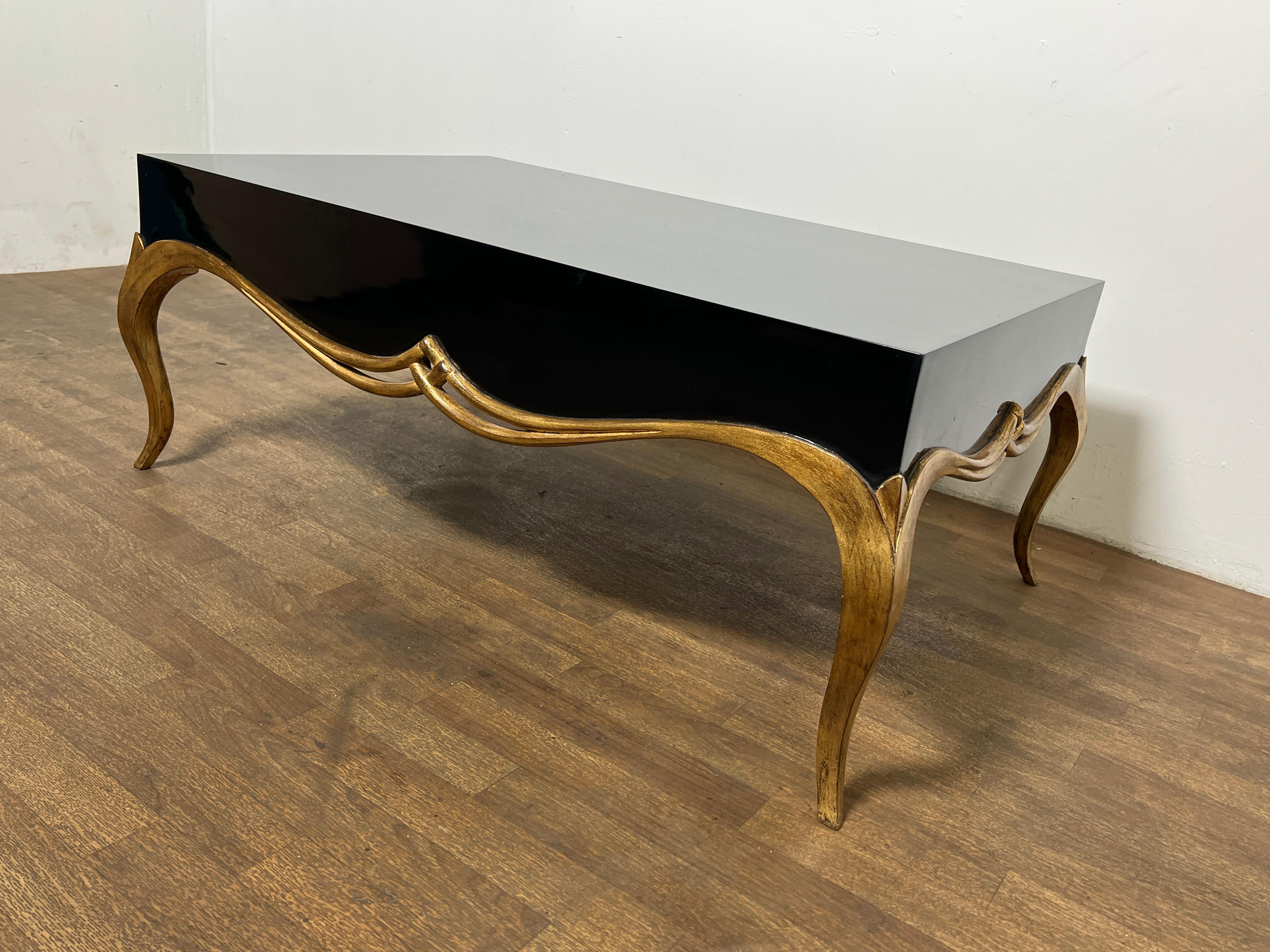 A coffee table in highly polished lacquer with gilt wood accents from the 