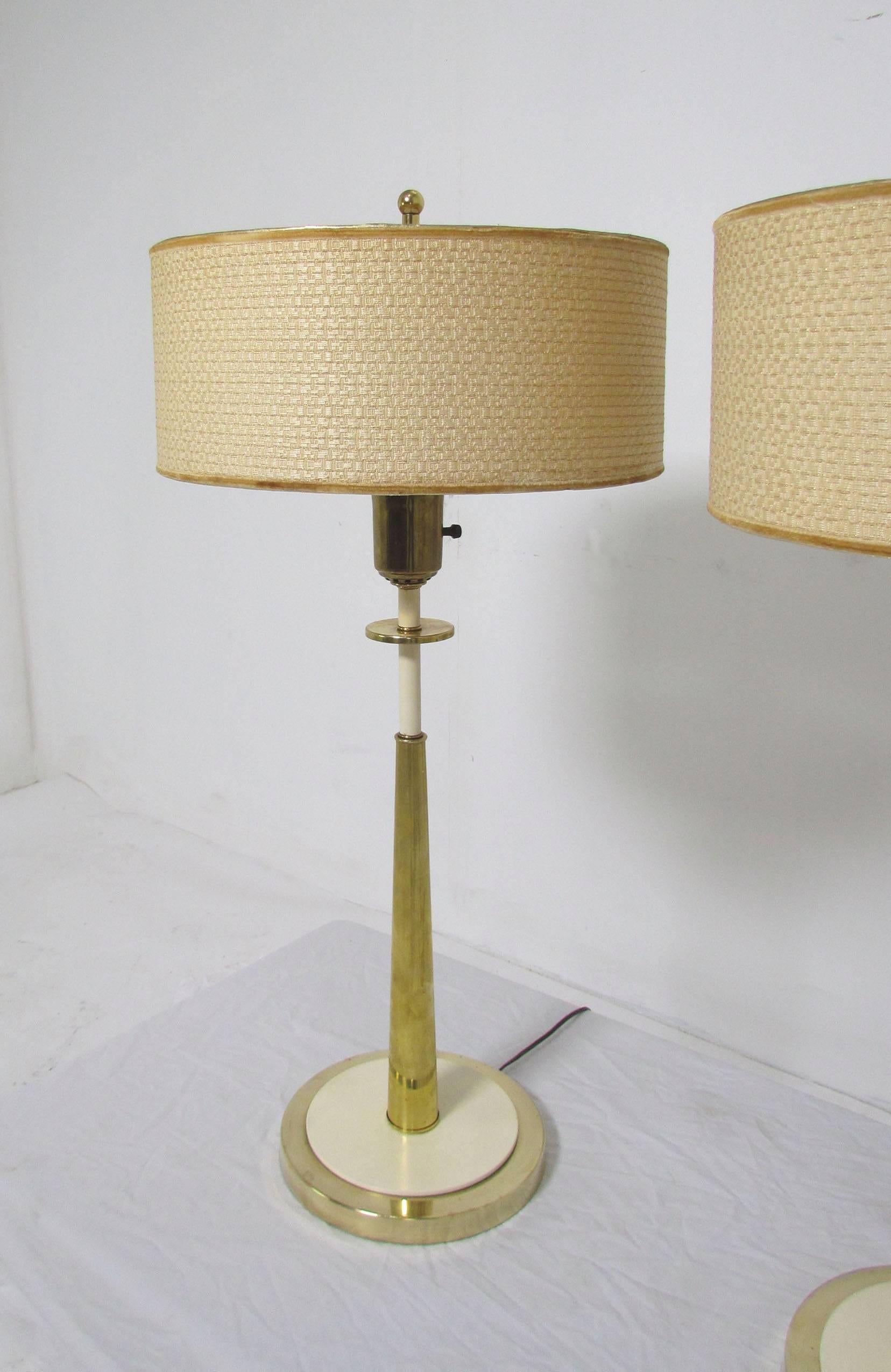 Pair of slender brass table lamps, in the manner of Tommi Parzinger designs for Stiffel. Original shades, finials, and glass diffusers, circa late 1950s-early 1960s.

Measures: 34