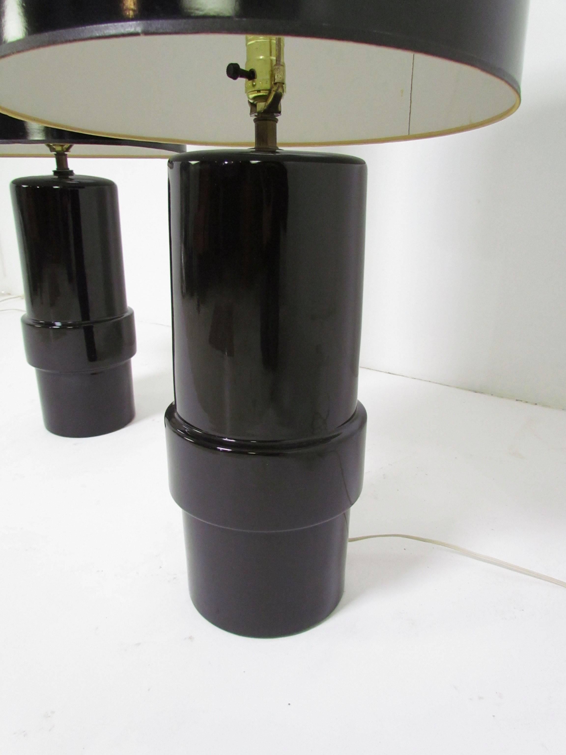 Pair of large cylindrical black ceramic lamps with original shades, circa 1970s. Overall height with shades is 37.25