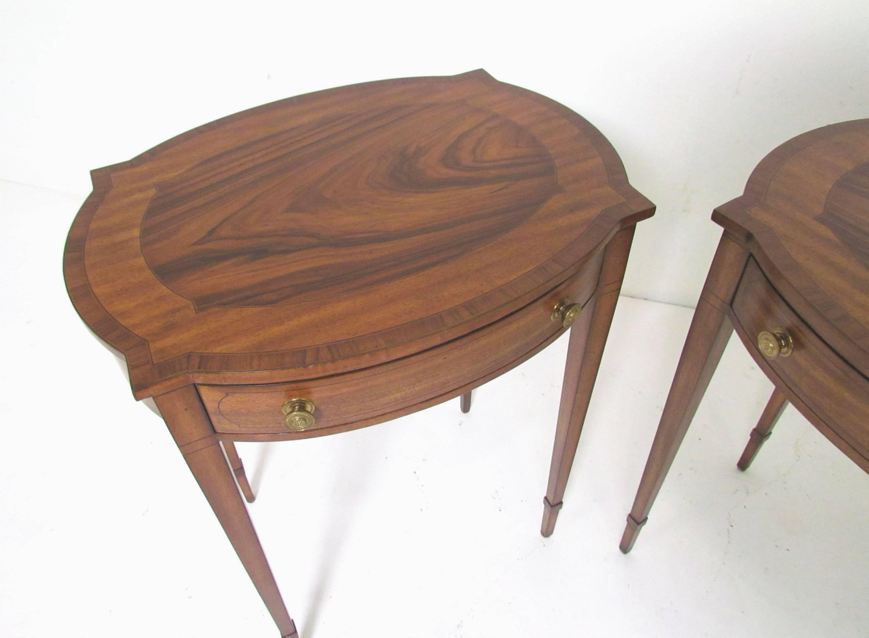 Pair of elegant English Regency style end tables by Maitland-Smith. Single drawer stands with mahogany inlay and gracefully tapered legs.
