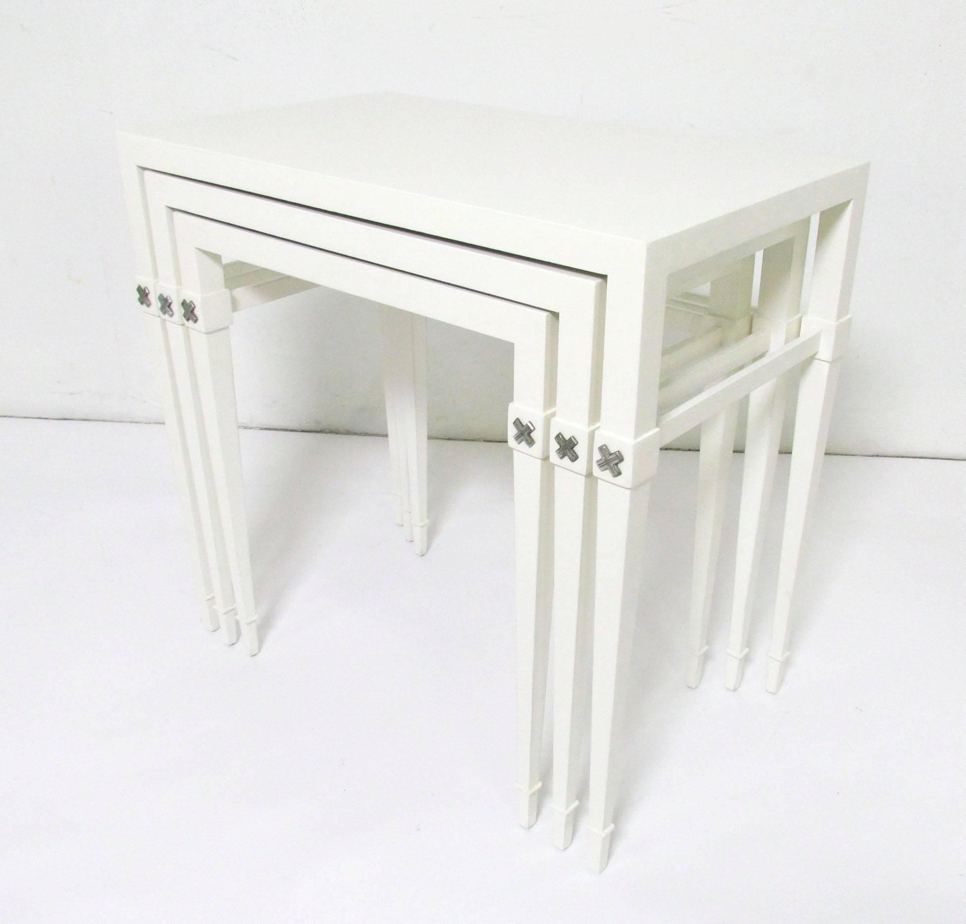 Set of three nesting tables, lacquered wood with nickel accents, by Tommi Parzinger for Charak Modern, circa 1950s.

Largest table measures 25.5