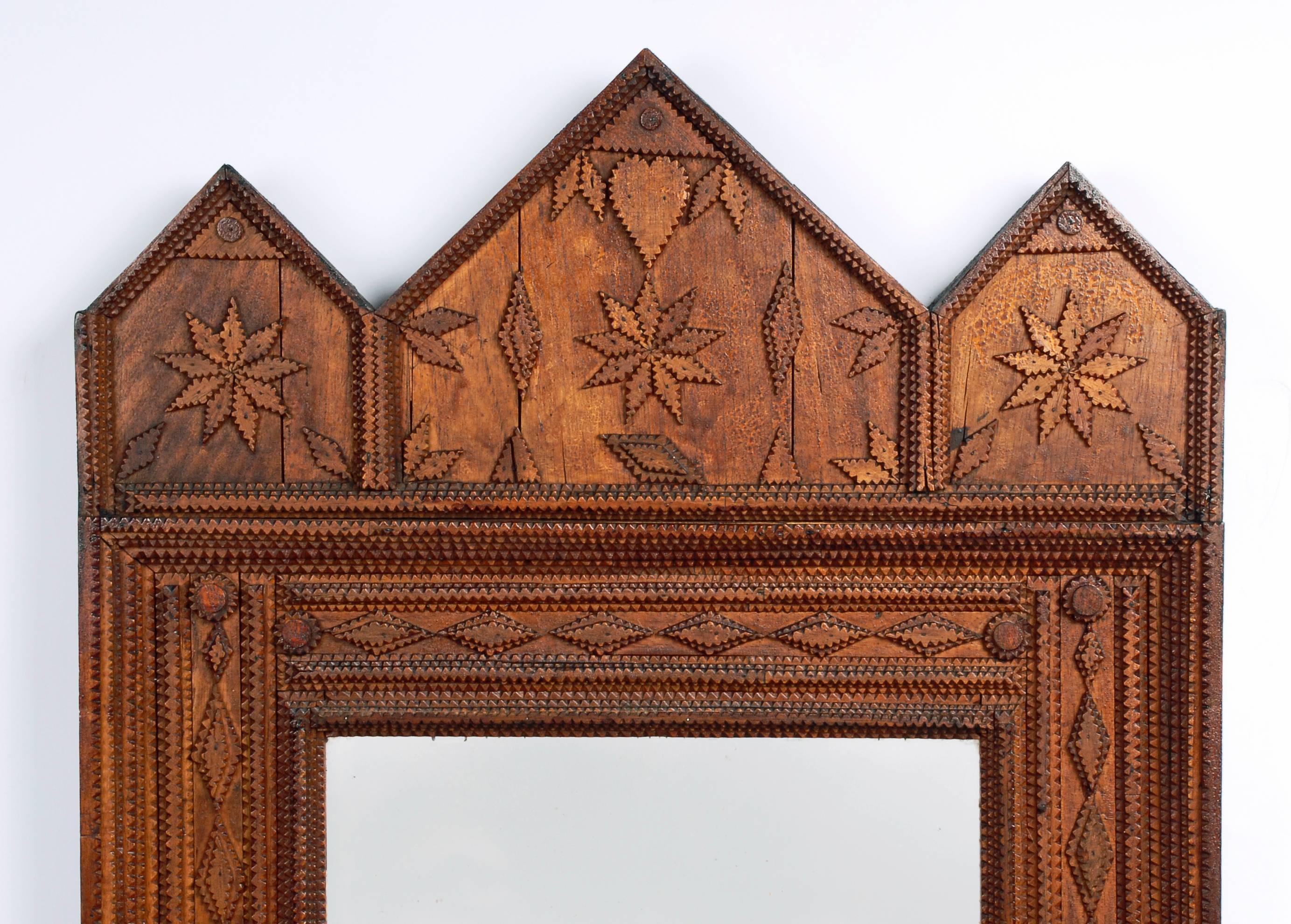 A large Tramp Art mirror heavily embellished with carved hearts and snowflakes.

circa 1900.