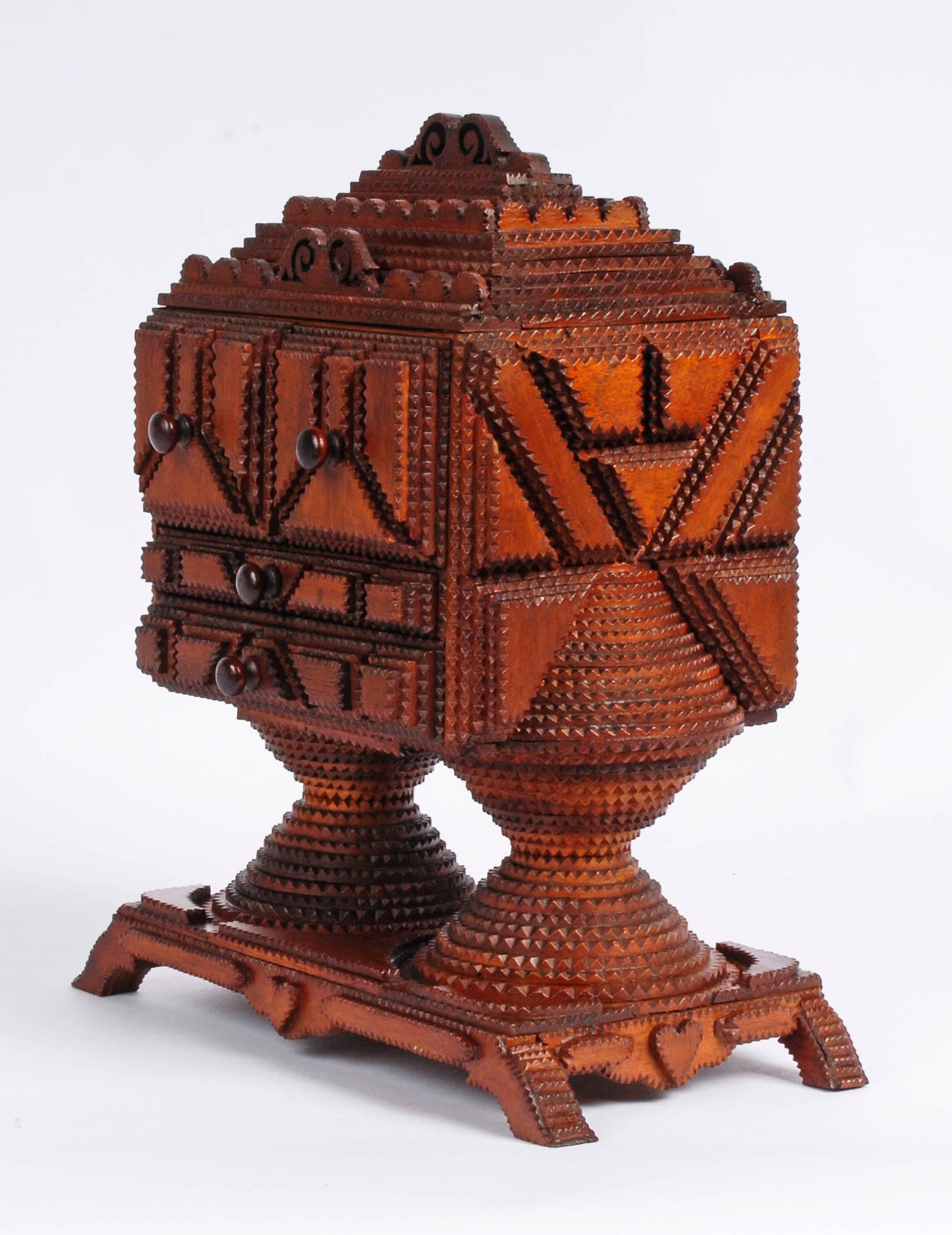 A significant sculptural Tramp Art conical based pedestal box with four drawers. One of the best Tramp Art objects with an impressive texture of patterning and exhibiting a rich patina. The conical spheres supporting the top are 22 layers deep. It
