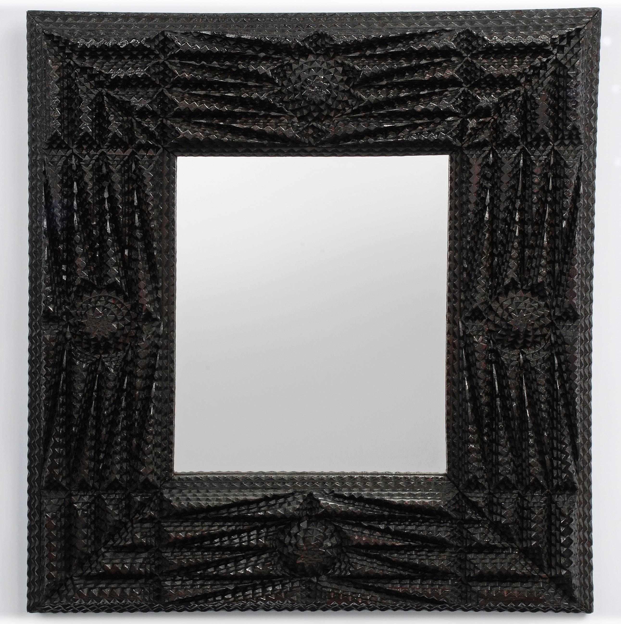 A deeply layered Tramp Art mirror profusely embellished with carved rosettes and strips of graduated layers.

New Orleans, LA,
circa 1890-1910.