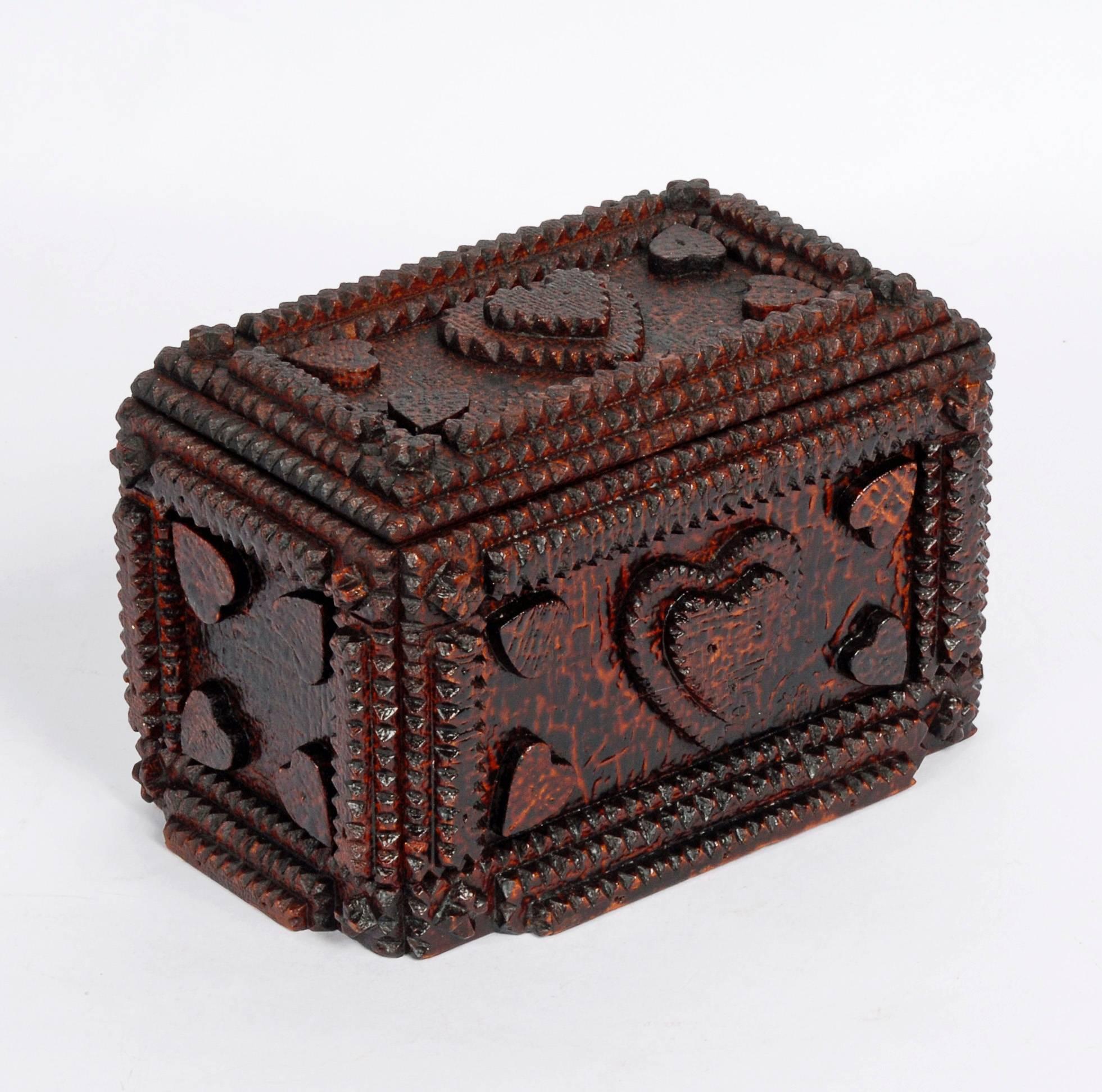A petite Tramp Art box embellished with numerous hearts and a desirable crazed finish. It was perhaps given as a gift to someone special. The use of hearts in Tramp Art attests to the artist’s drive to make objects having a deep emotional
