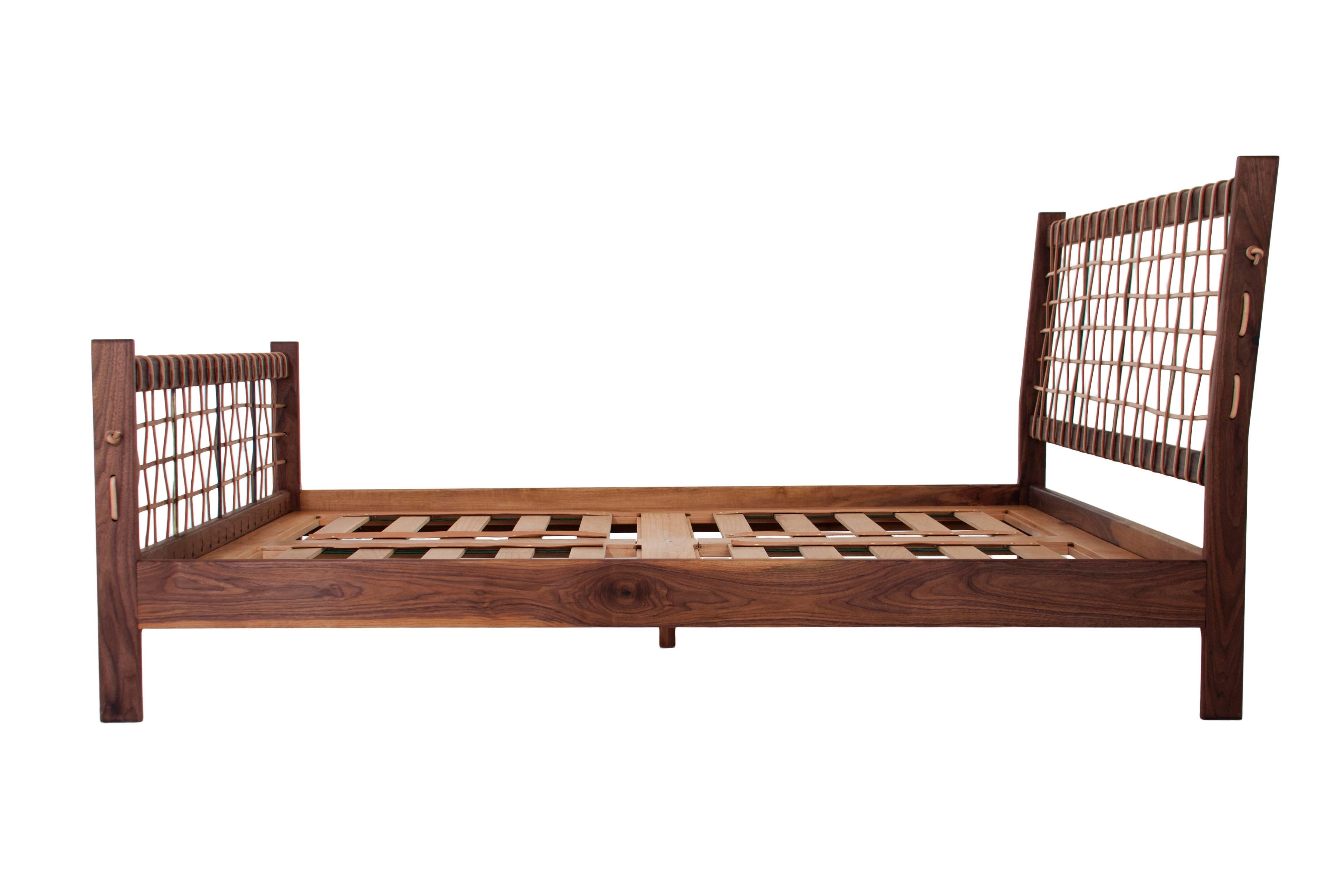 A custom figural walnut bed frame with a natural woven leather cord headboard and footboard. The frame has brass detailing and a stretched cord knot at each end. Avaliable in a variety of wood finishes, natural or black cord, steel or brass plugs.