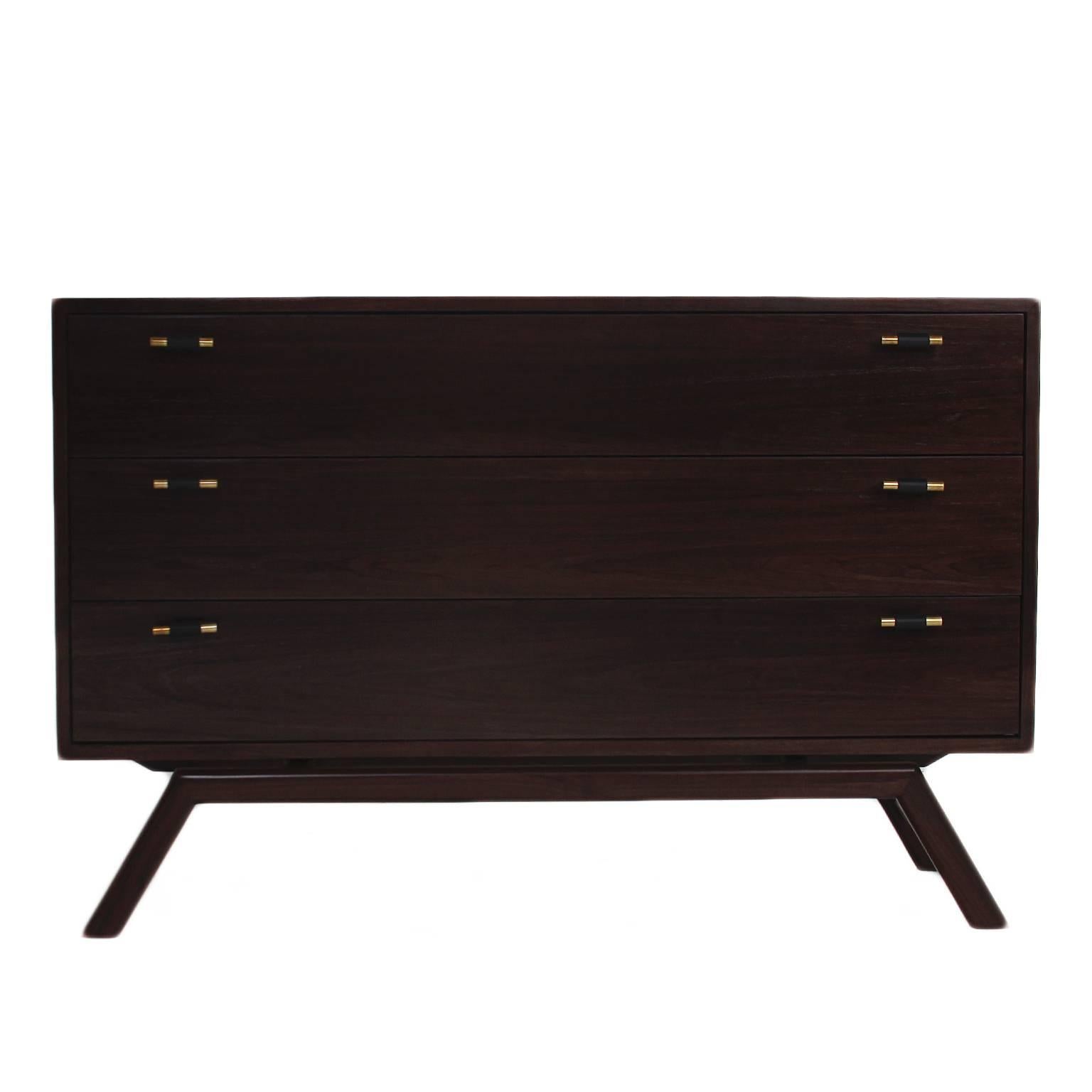 A beautiful dresser made of Walnut veneer with a sculptural base made of solid walnut. There are 3 drawers with leather wrapped Brass pulls.

This particular cabinet is made of solid walnut with a dark walnut satin lacquer finish.

The price is