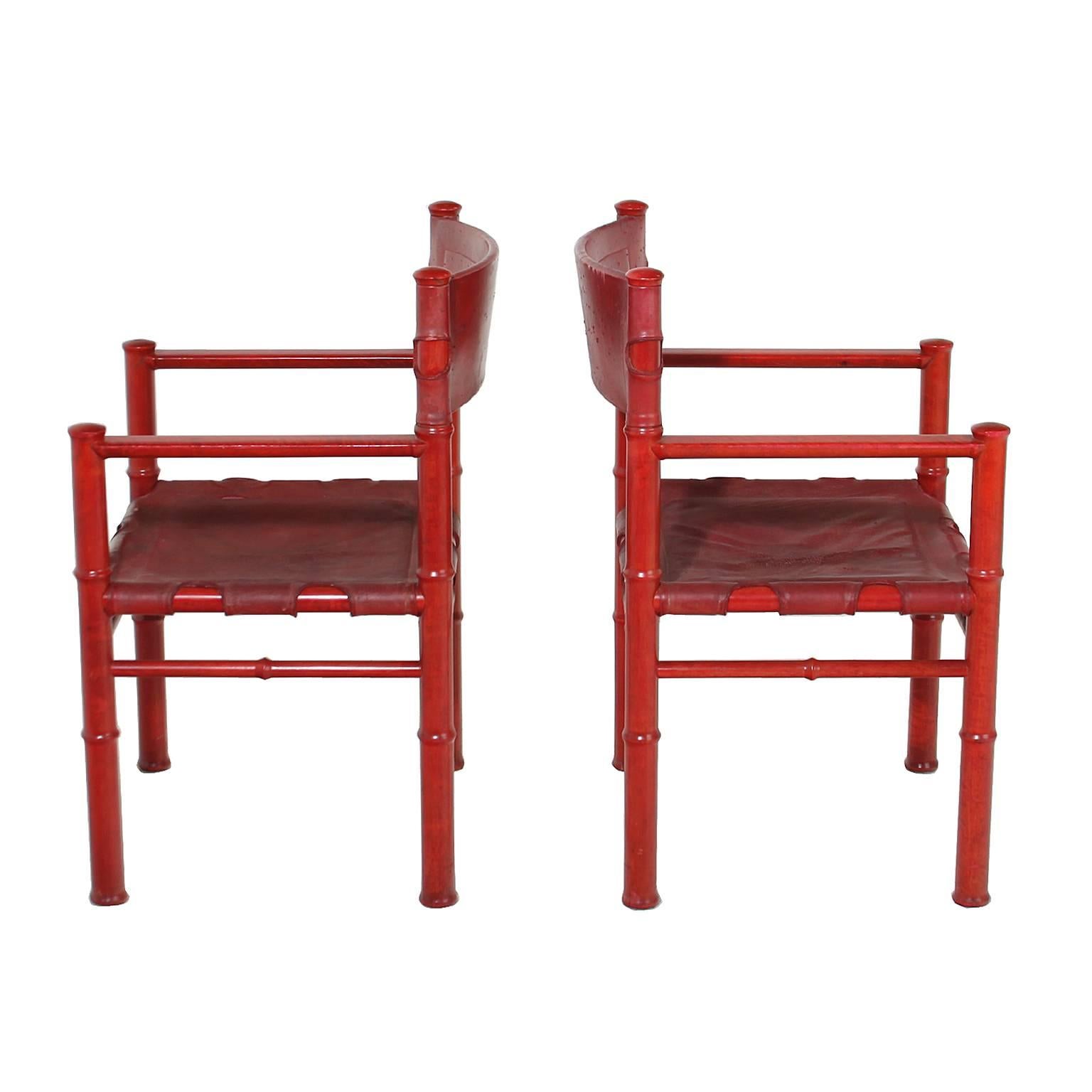 A pair of vintage red leather chairs. The leather sling is original and has minor wear due to age. 

Seat height 17.
Seat depth 17.

Many pieces are stored in our warehouse, so please click on 