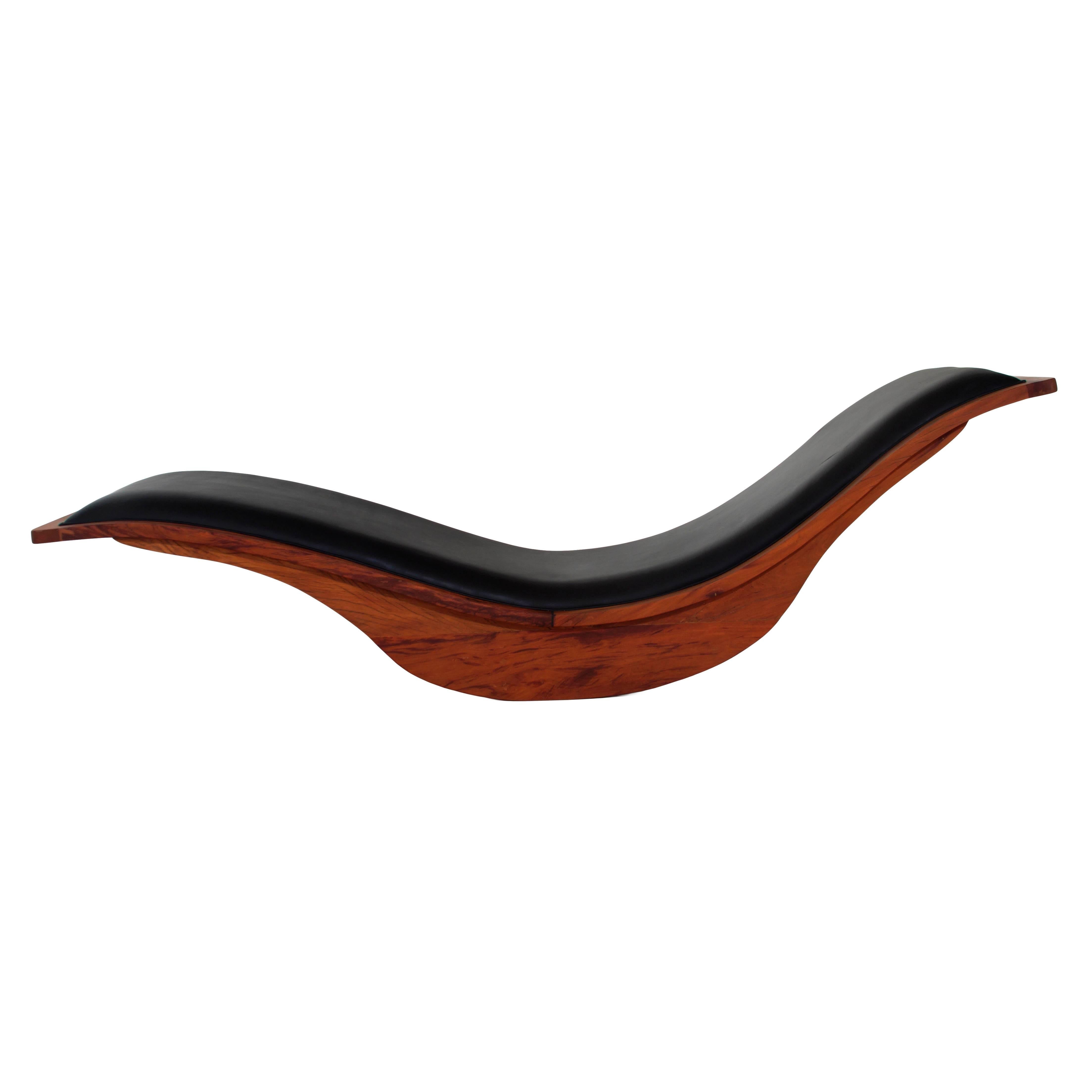 This is a swooping rocking chaise lounge composed of exotic Brazilian peroba hardwood with a smooth leather seat by Brazilian designer Igor Rodriguez. The design is sleek and incredibly comfortable.
 