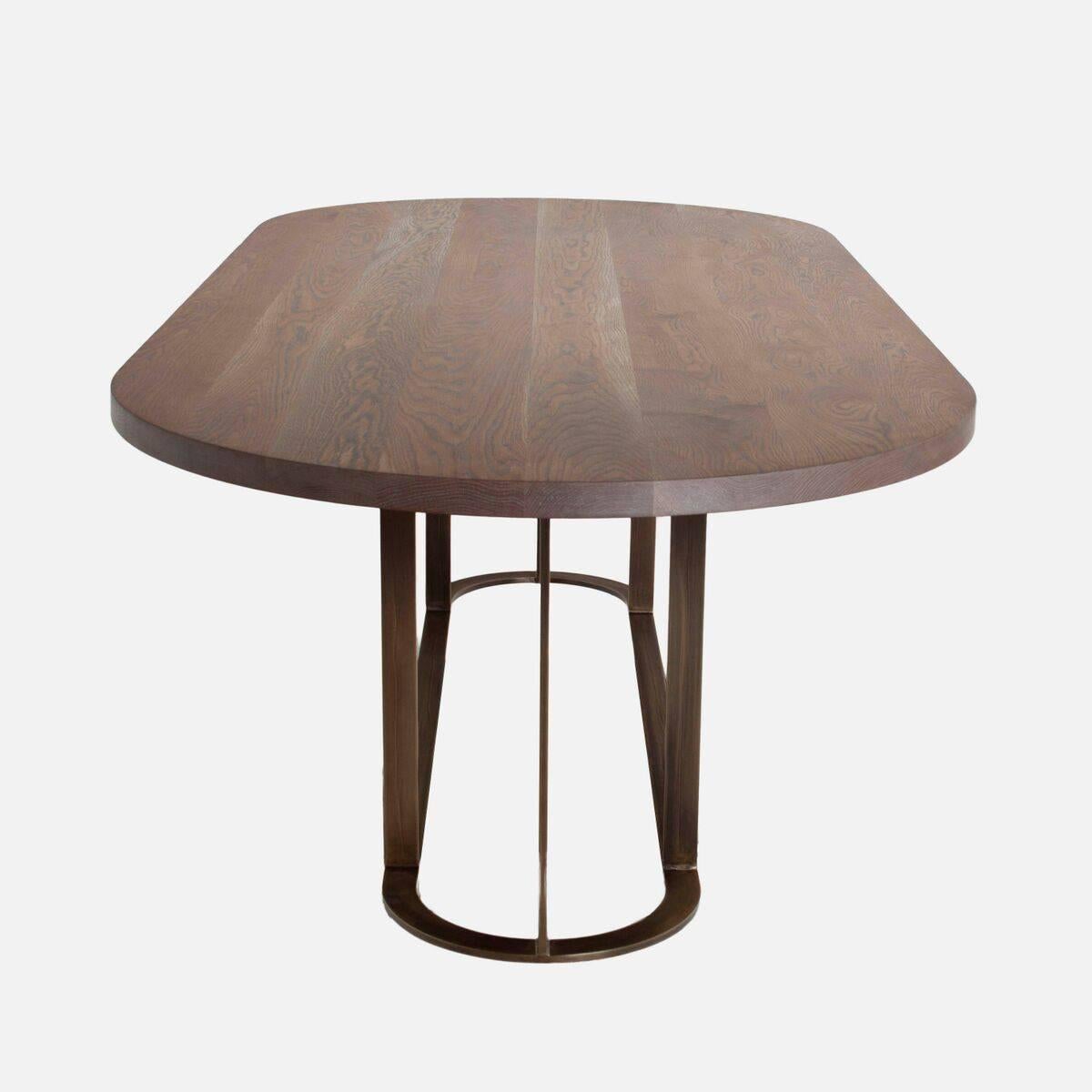 A custom dining table consisting of a structural metal base and a solid figural wood top in a variety of finishes. See the finish options in the last image. 

Standard Dimensions: 102”W x 44”D x 30”H

Lead Time 10 - 12 weeks

Base options: steel or