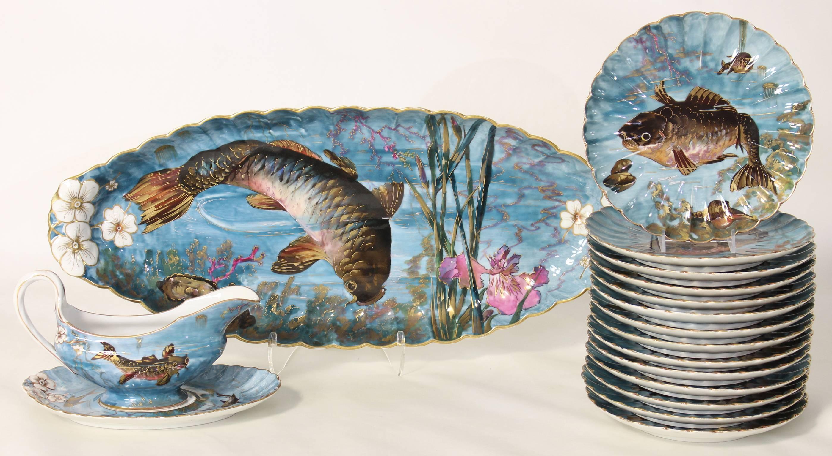 This complete set of elaborately decorated fish service is hand-painted in a rich blue color in the Aesthetic Movement style with all over polychrome enamel. The 14 plates each depict an aquatic scene with a different fish surrounded by lobsters,