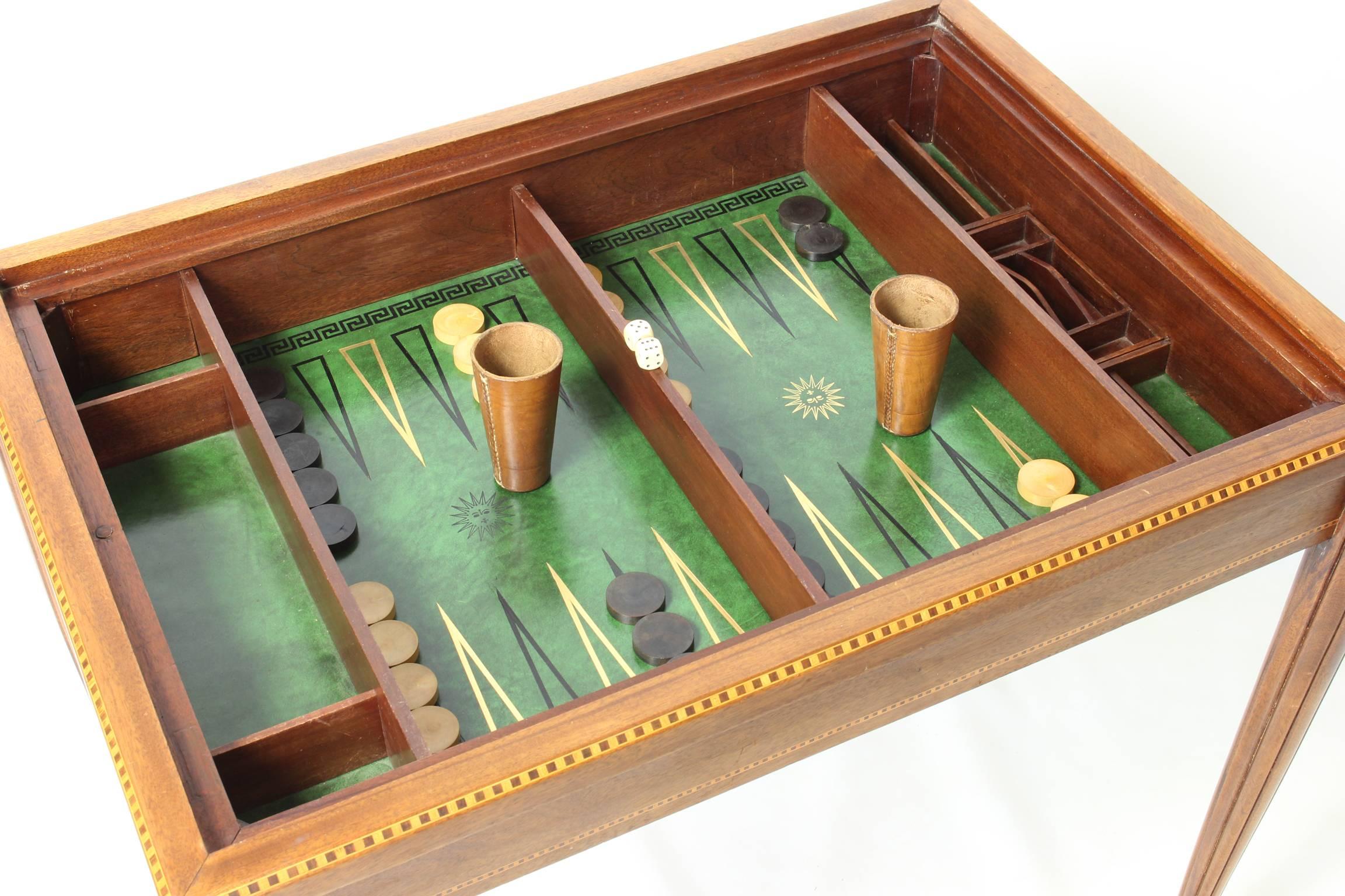 A small and very elegant French Art Deco backgammon or games table attributed to Paul Follot. When the fitted top is removed the interior reveals a green tooled leather backgammon surface, an additional chess board is housed within the table as well