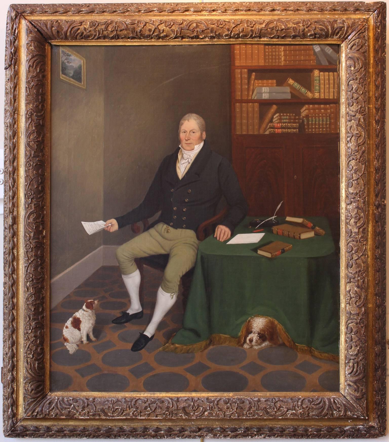 A beautifully painted and very charming English oil painting of a seated gentleman in a library setting with his two adoring King Charles Spaniels. Signed on the back right corner of the lined canvas by listed UK artist Edmund Ward Gill, 1794-1854.