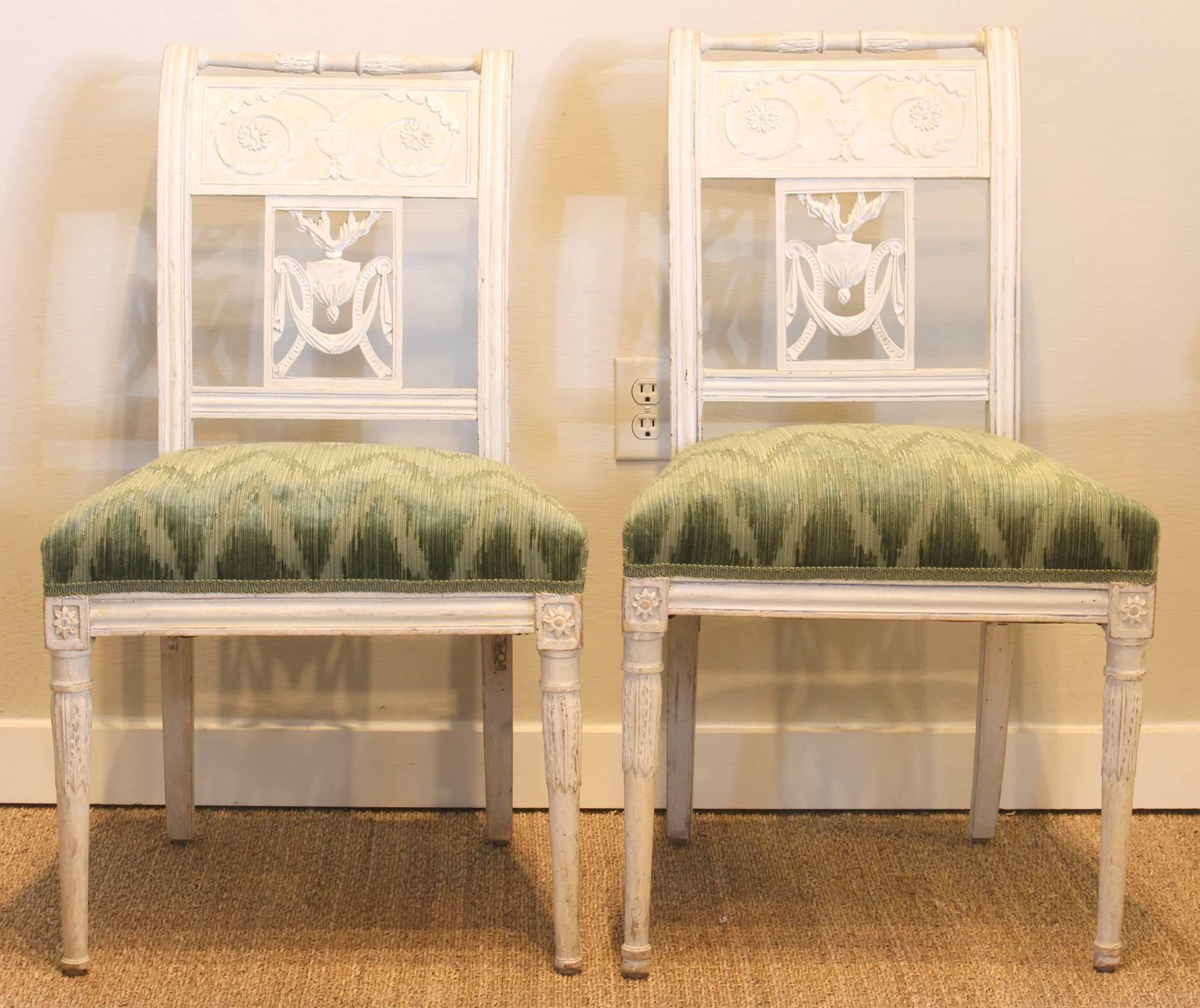 An elegant pair of late 18th century Baltic side chairs with beautifully carved and pierced back splats. The chairs appear to retain their original flat white paint. The seats are newly upholstered in a blue-green Colefax & Fowler fabric.