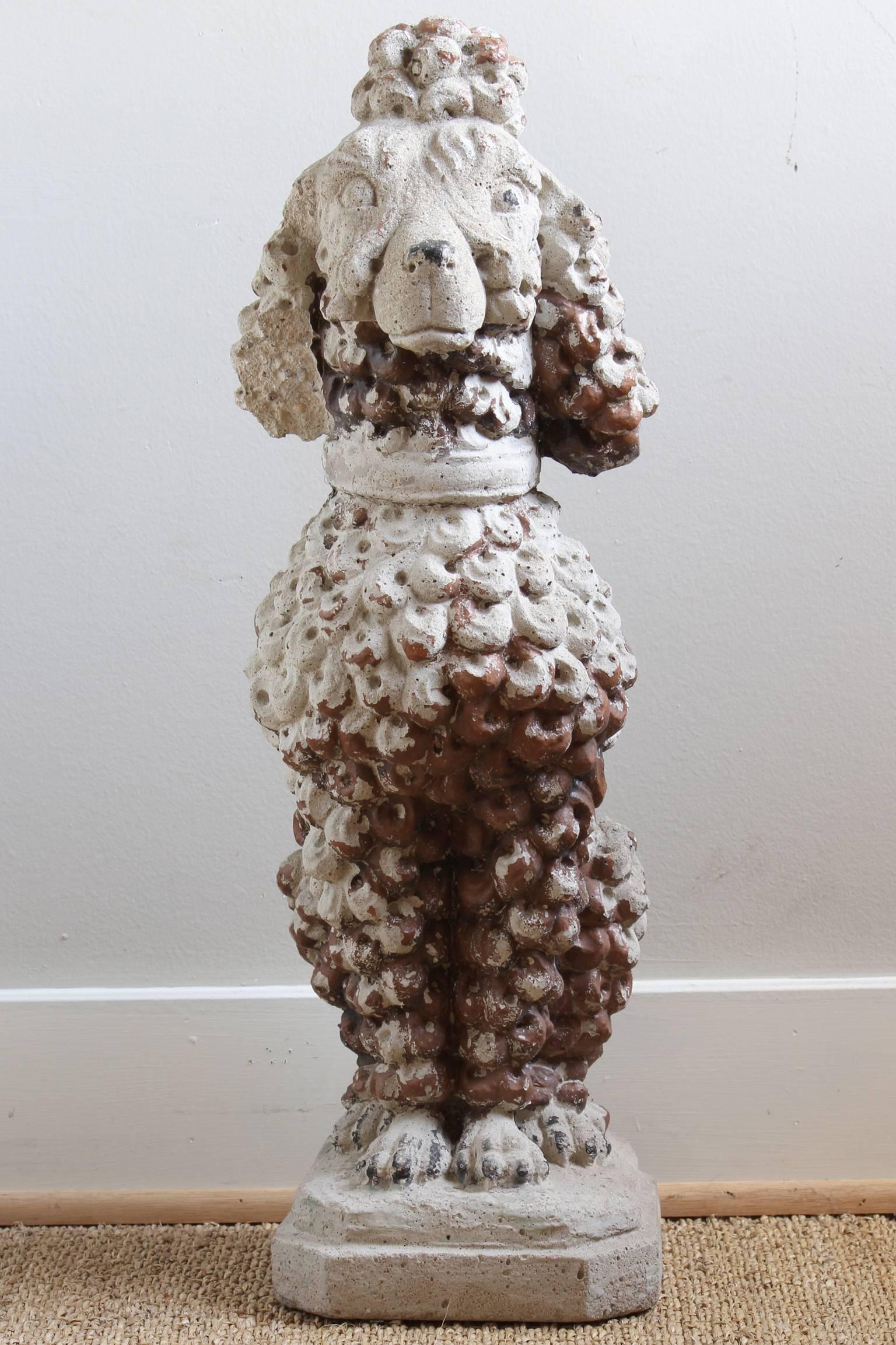A charming cast stone French poodle dating from the 1940s. The dog retains traces of old brown paint throughout.