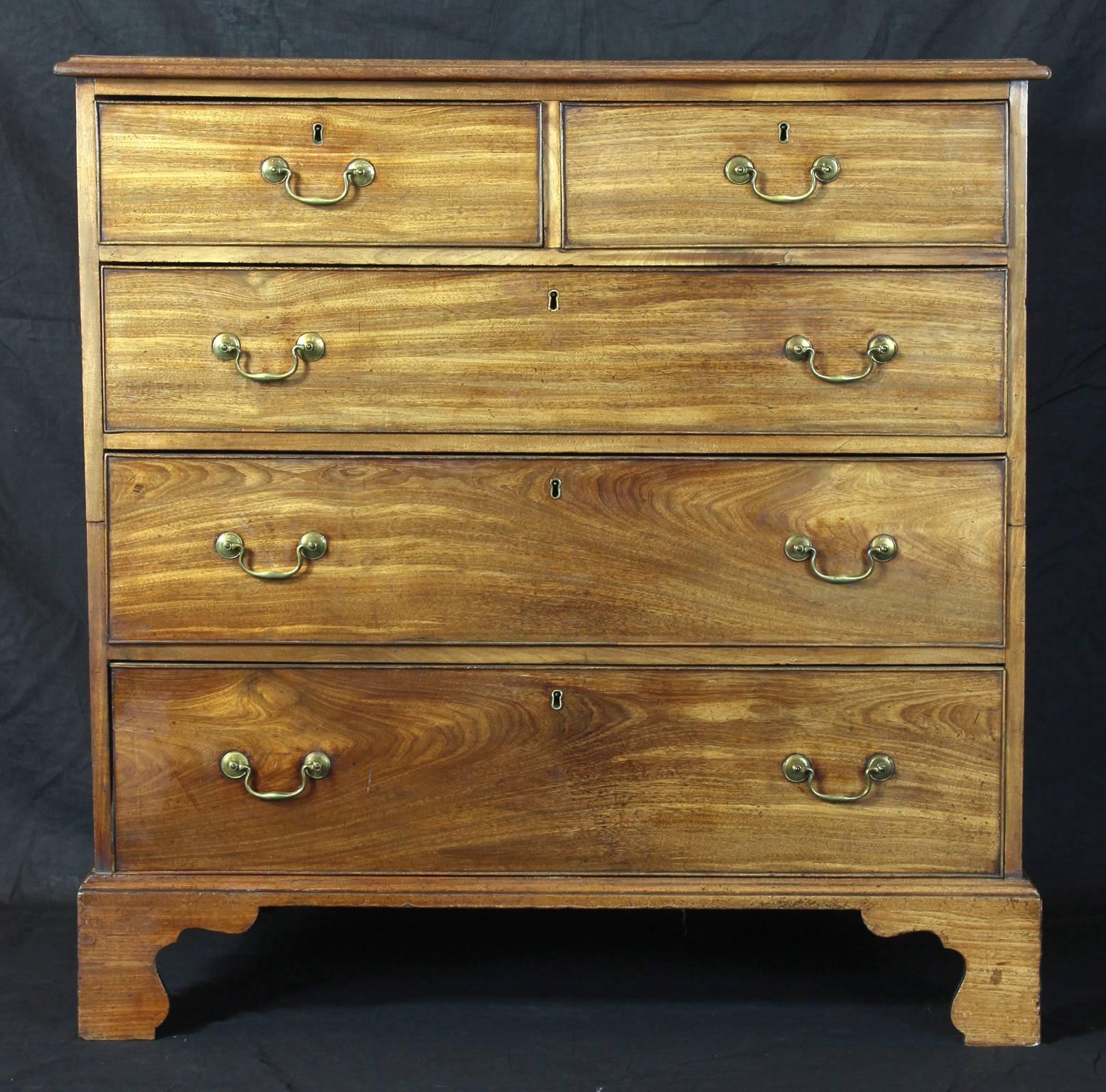 An elegant late 18th century sun faded mahogany chest of drawers with two short and three graduated long drawers with original brass handles and bracket feet.