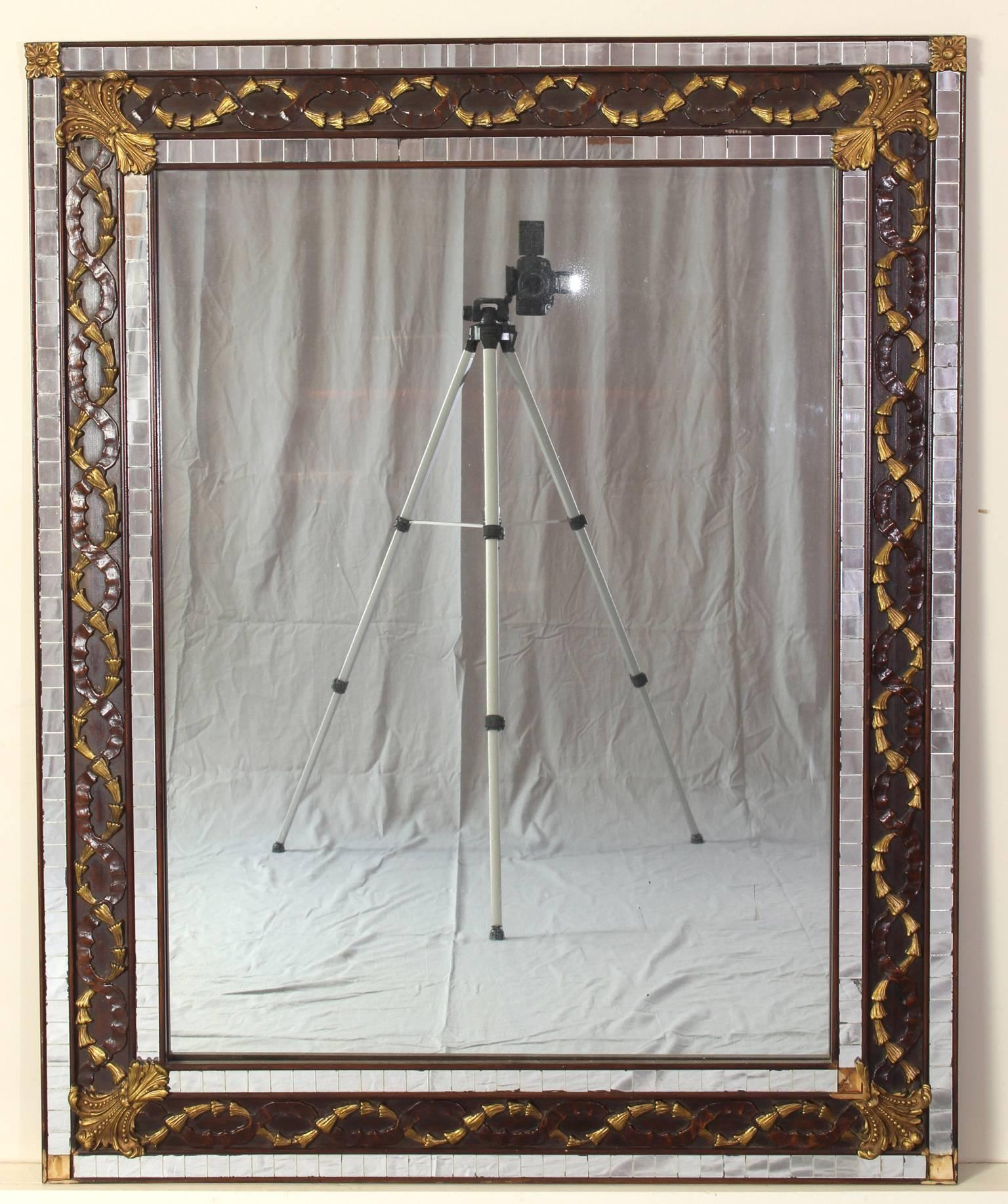 A large Art Deco carved wood and mosaic mirror with gilt accents.