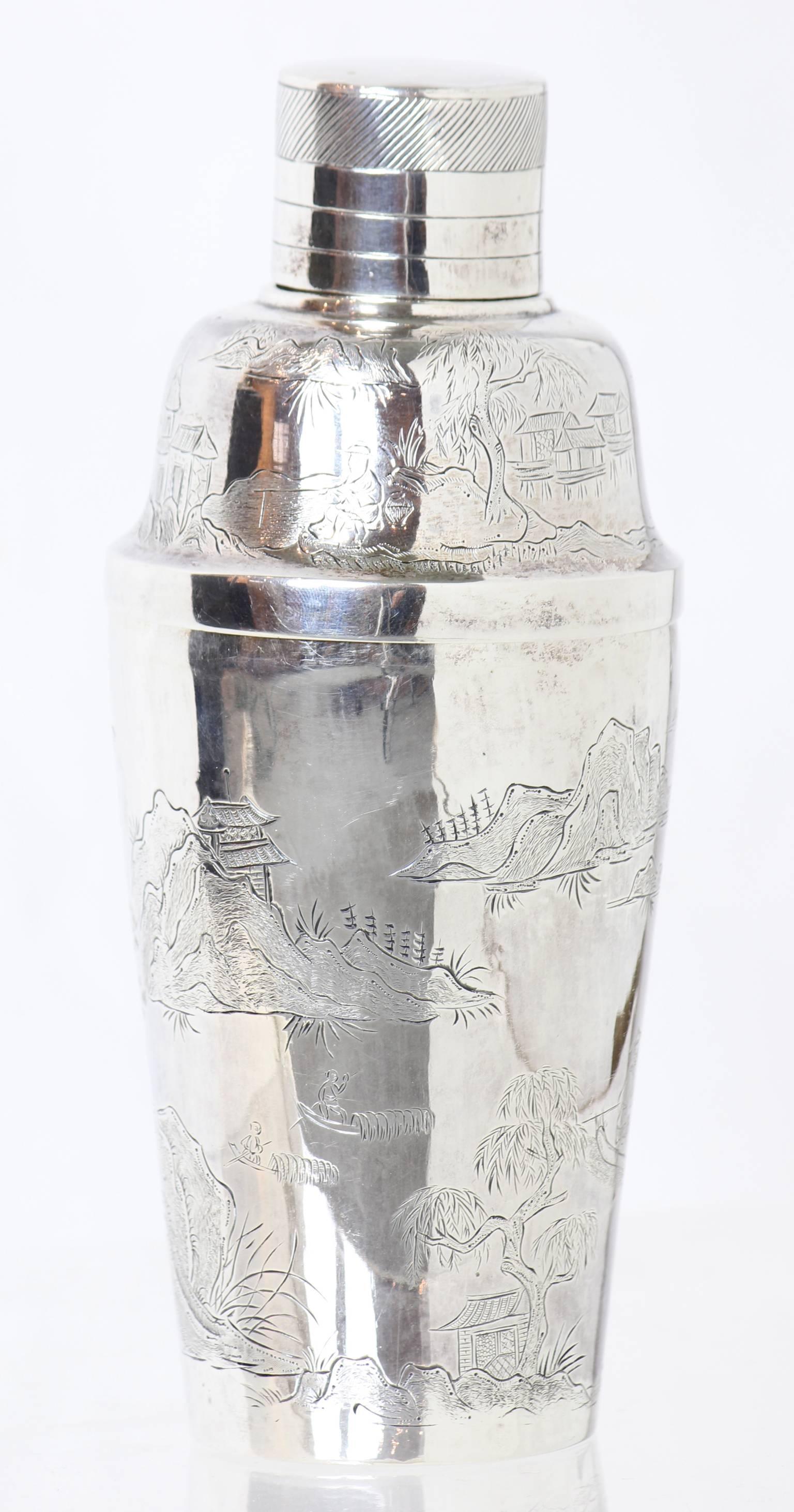 An early 20th century Chinese Export solid silver cocktail shaker heavily engraved with mountains and trees in a village setting. Monogramed with a 