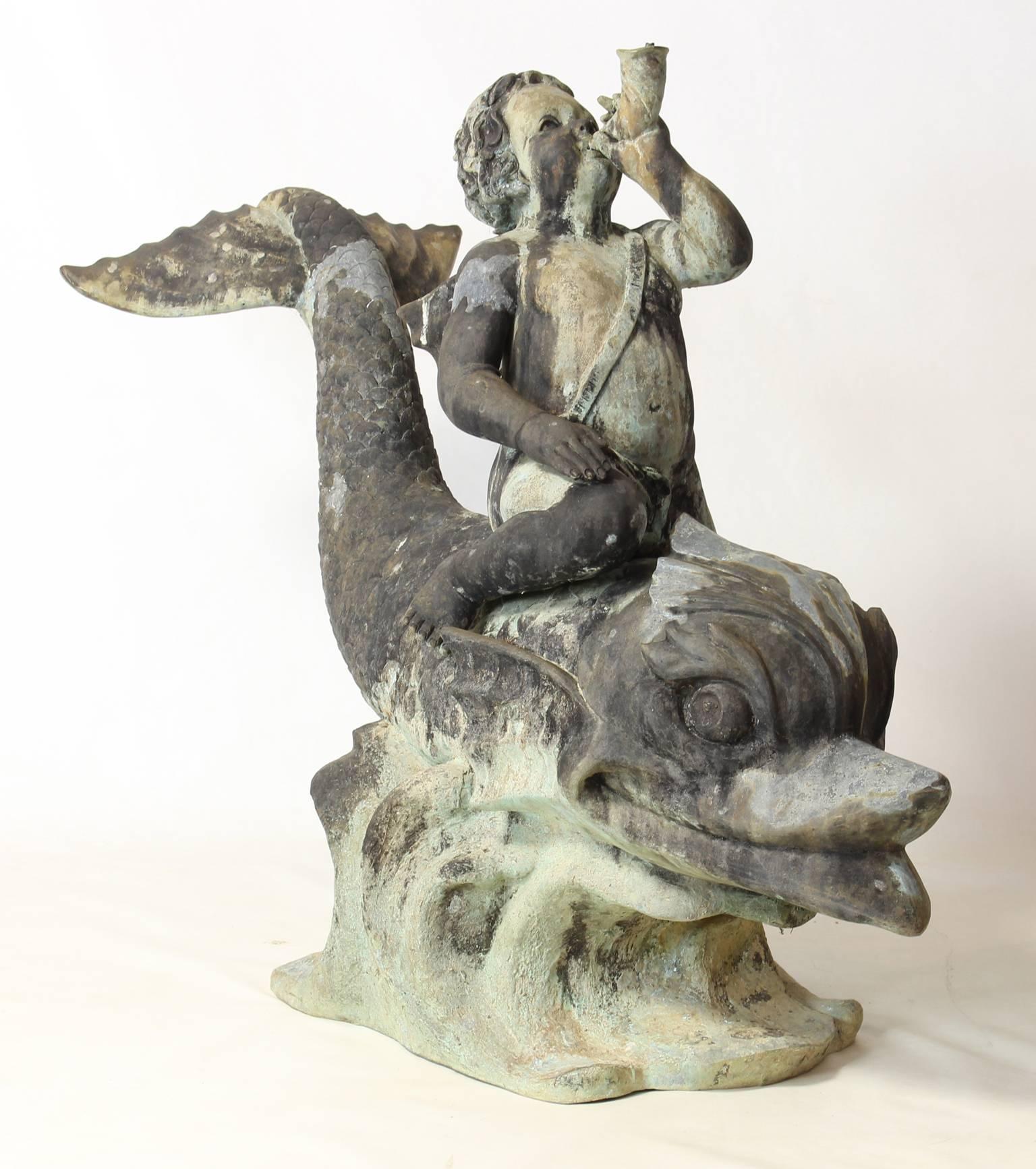 A large and whimsical late 19th century finely detailed Italian cast bronze fountain of a cherub astride a frolicking dolphin.