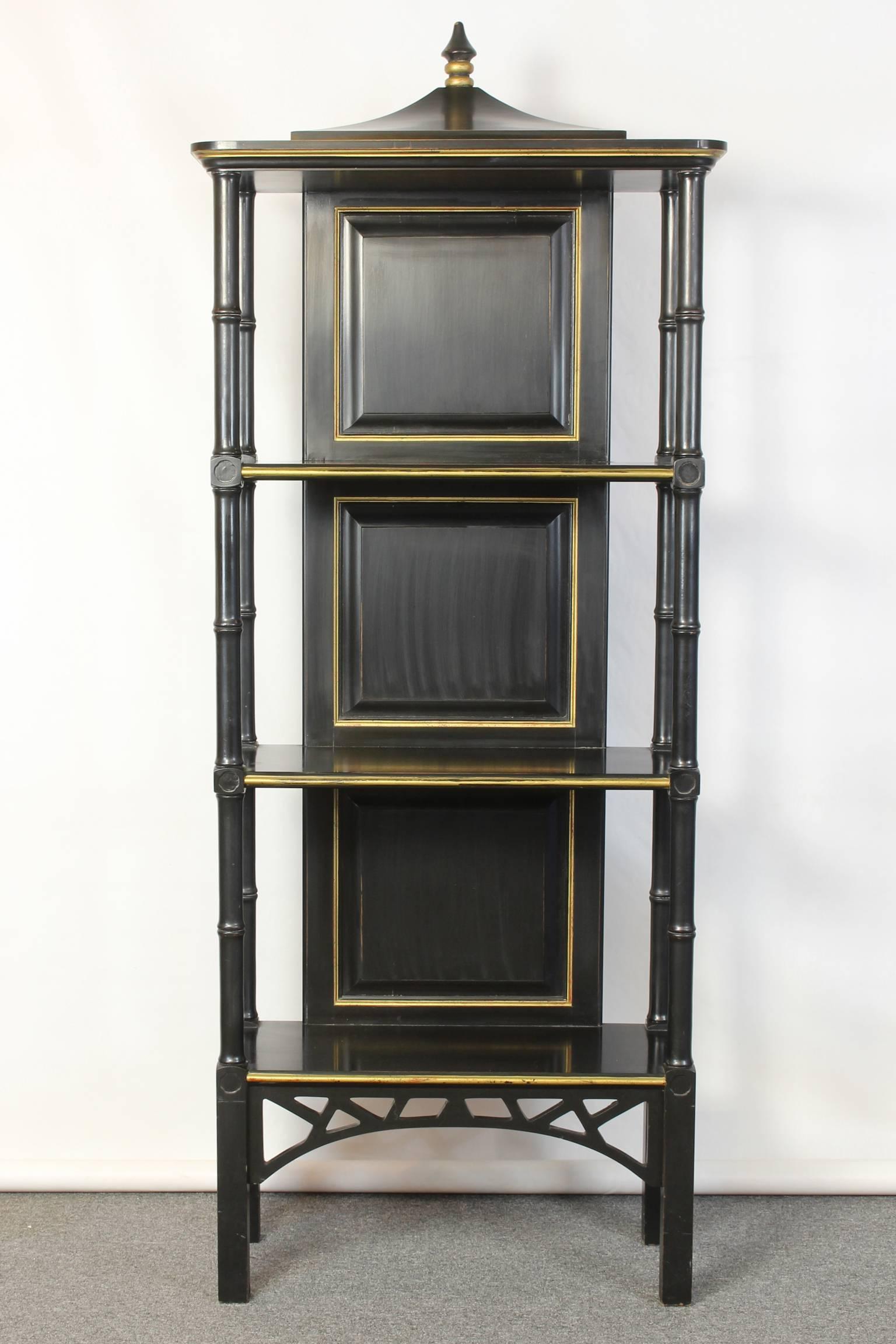 A charming chinoiserie inspired three shelf étagère in black and gold carved wood.