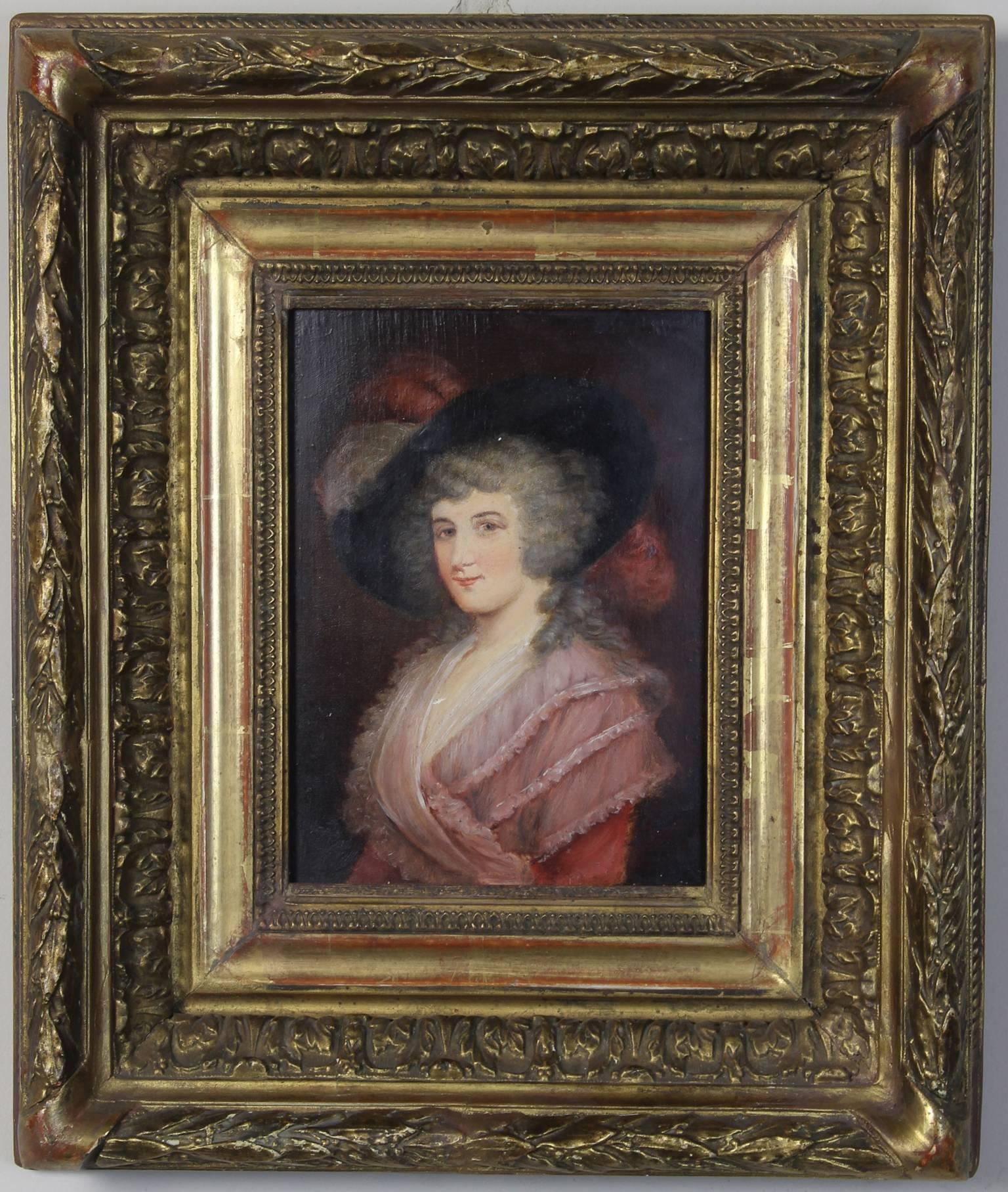 A small and elegant oil on board portrait of a lady in an exceptional early carved giltwood frame.