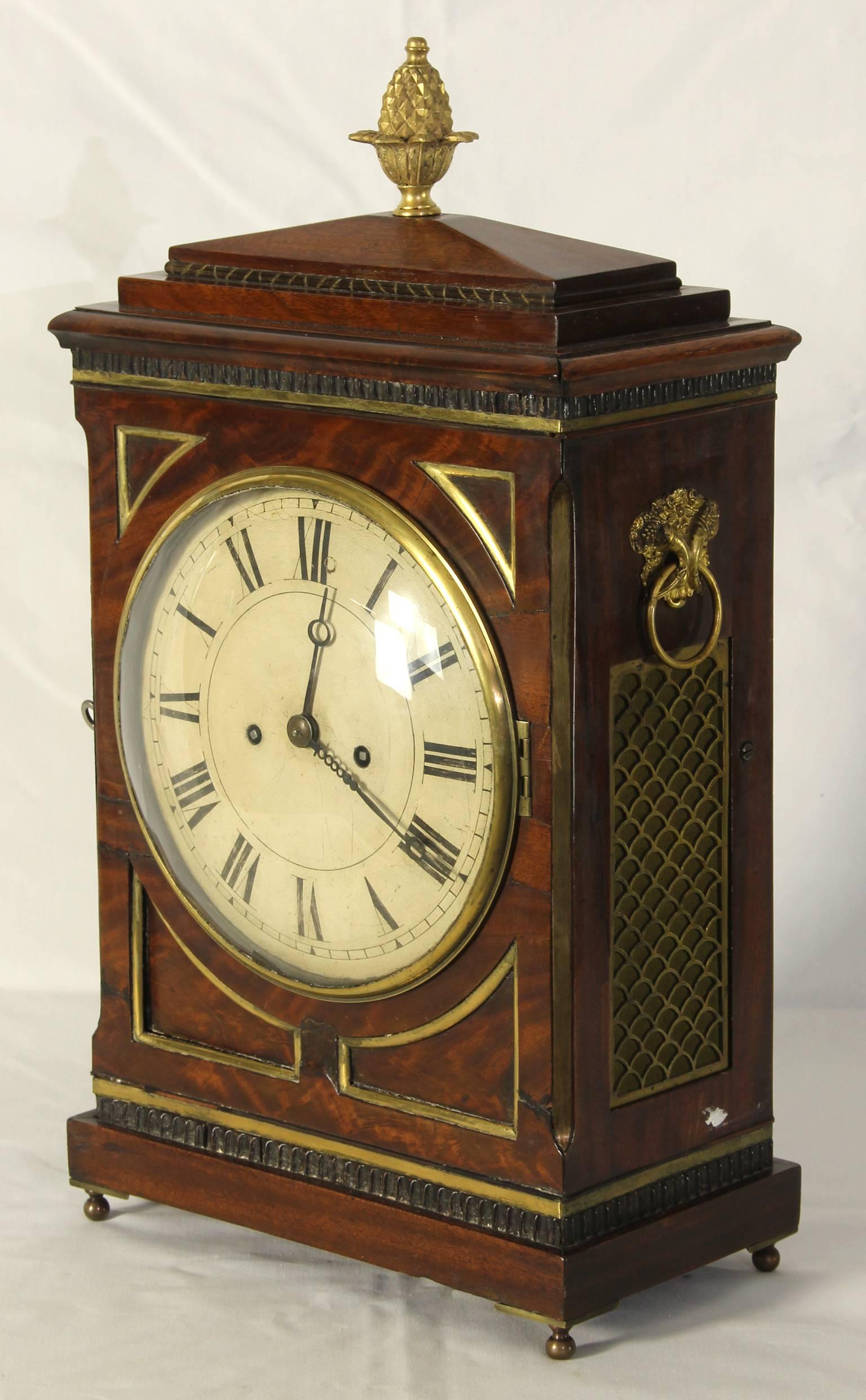 An elegant English Regency (circa 1815) 8-day mahogany and brass inlay mantel clock with chamfer top and gilt bronze finial.