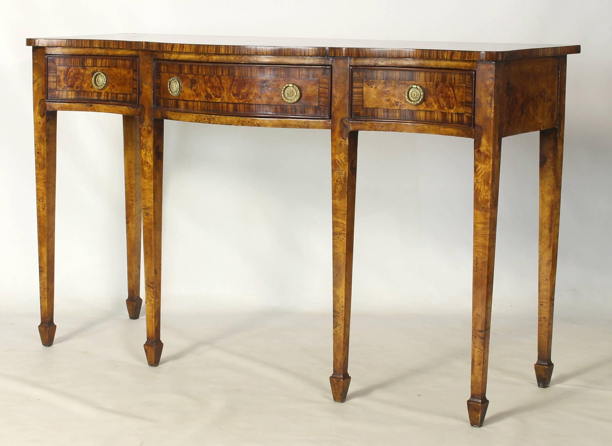 An elegant burle walnut and rosewood serpentine front three-drawer console table with tapering square legs terminating in spade feet.