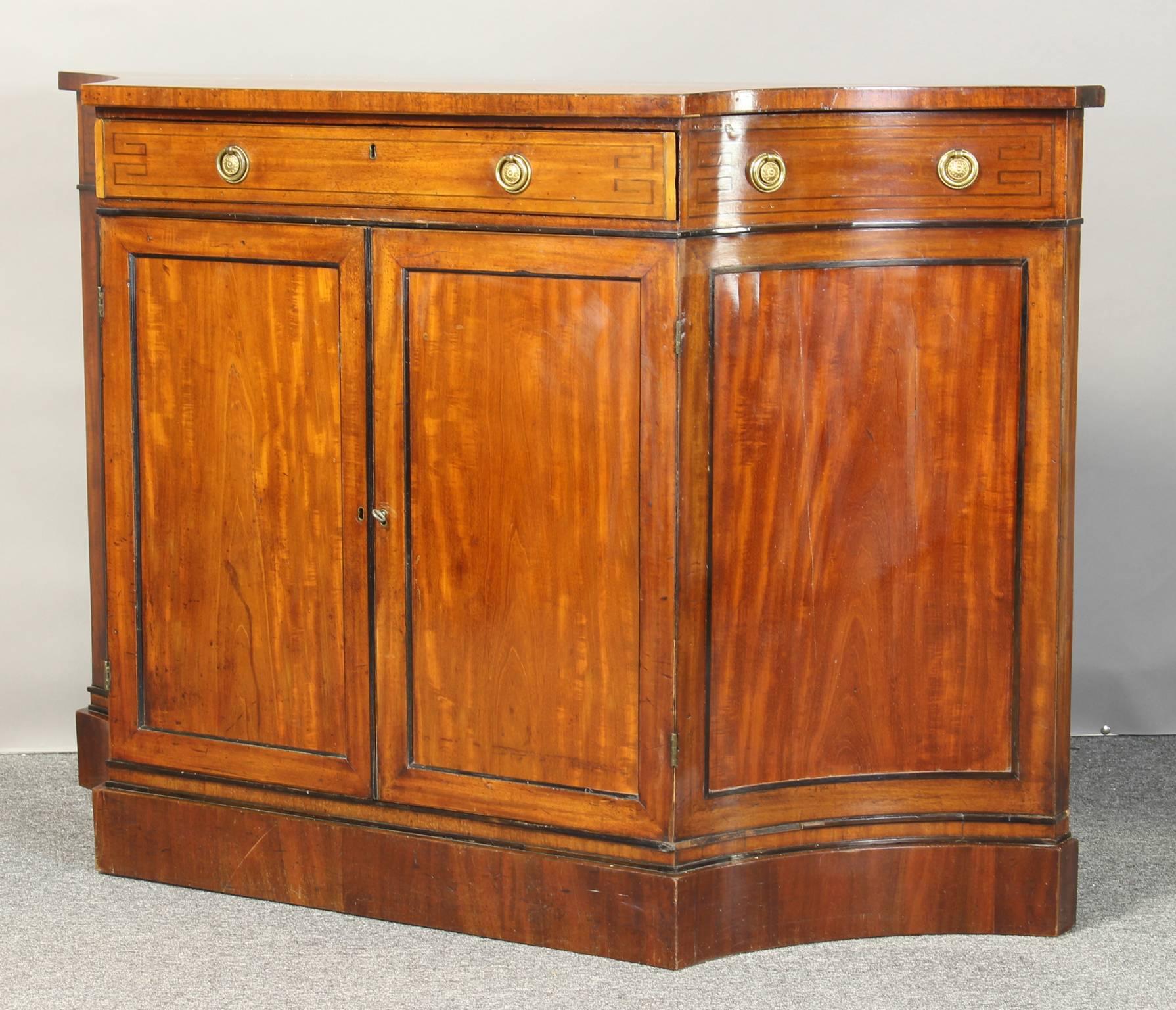 A small and elegant early 19th century Regency credenza with ebony stringing and original gilt brass pulls.