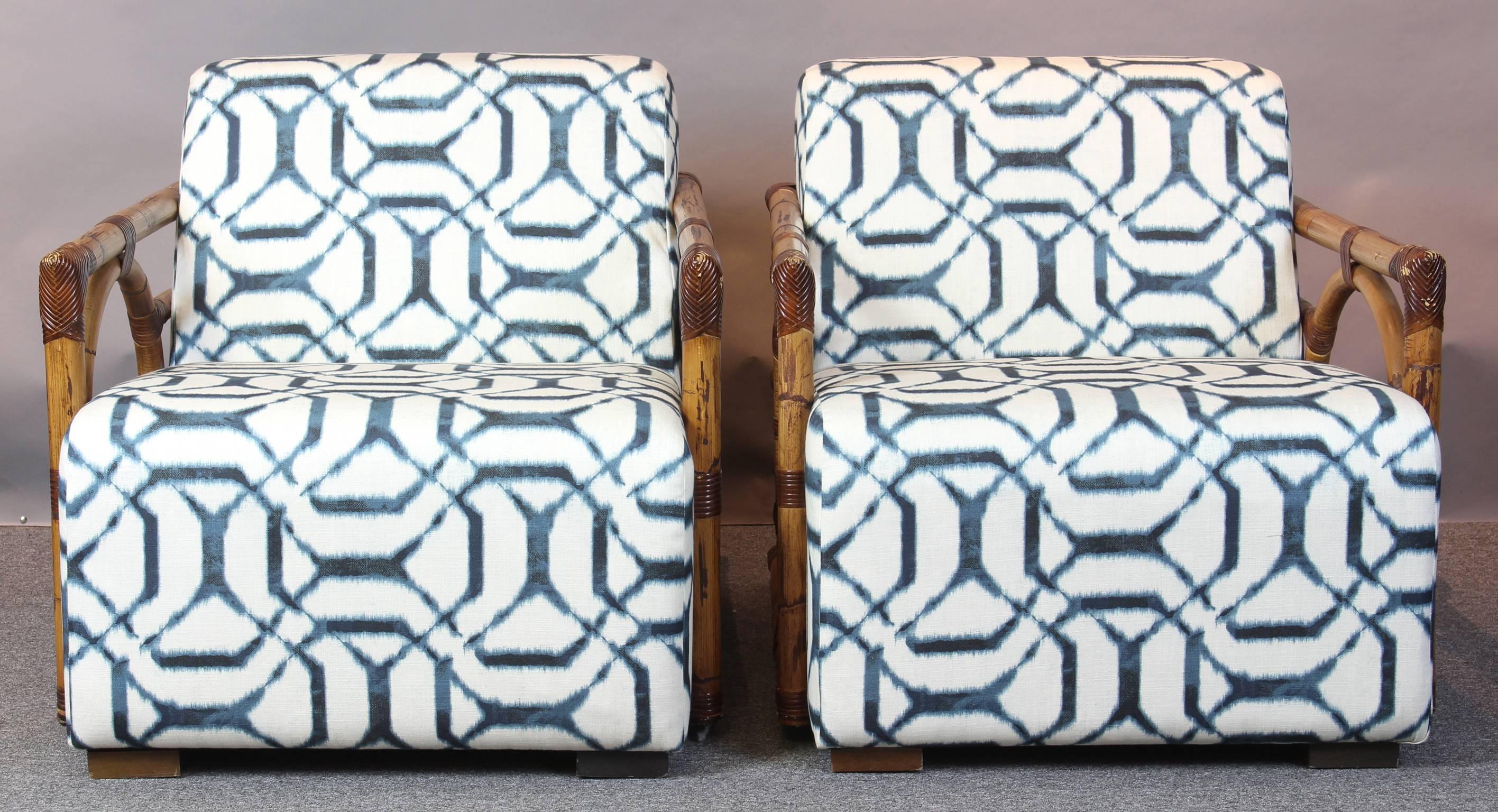 A wonderful pair of highly decorative Art Deco inspired rattan lounge chairs. The rattan displays exceptional color and finish, all bindings are complete and intact. The chairs have been recently upholstered in a cotton ikat fabric.